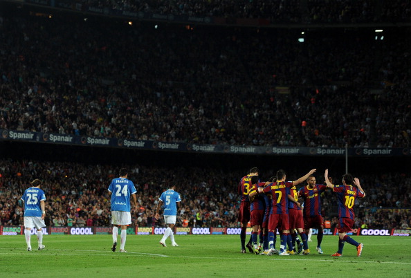 BARCELONA, SPAIN - APRIL 09: Lionel Messi (R) of Barcelona runs to join his teammates celebrating Thiago Alcantara his goal as Almeria players trudge back to the halfway line during the la Liga match between FC Barcelona and UD Almeria at the Camp Nou st