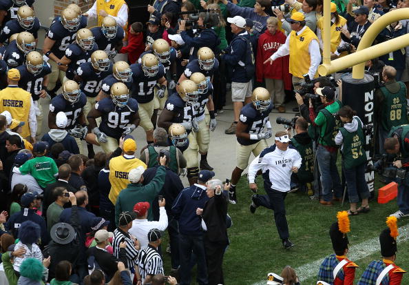 SOUTH BEND, IN - SEPTEMBER 25: Head coach Brian Kelly of the Notre Dame Fighting Irish leads his team onto the field before taking on the Stanford Cardinal at Notre Dame Stadium on September 25, 2010 in South Bend, Indiana. Stanford defeated Notre Dame 37
