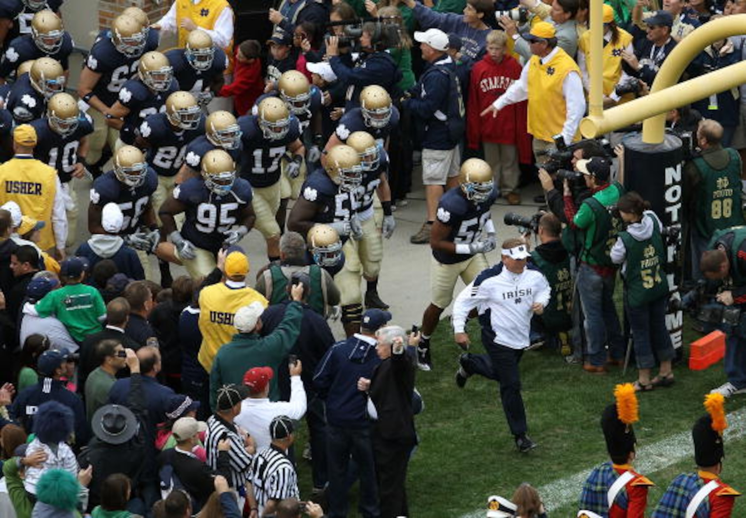 SOUTH BEND, IN - SEPTEMBER 25: Head coach Brian Kelly of the Notre Dame Fighting Irish leads his team onto the field before taking on the Stanford Cardinal at Notre Dame Stadium on September 25, 2010 in South Bend, Indiana. Stanford defeated Notre Dame 37