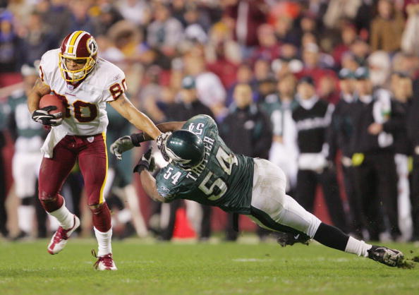 LANDOVER, MD - DECEMBER 12:  Wide receiver Laveranues Coles #80 of the Washington Redskins evades linebacker Jeremiah Trotte #54 of the Philadelphia Eagles during the game at Fed Ex Field on December 12, 2004 in Landover, Maryland.  The Eagles defeated th