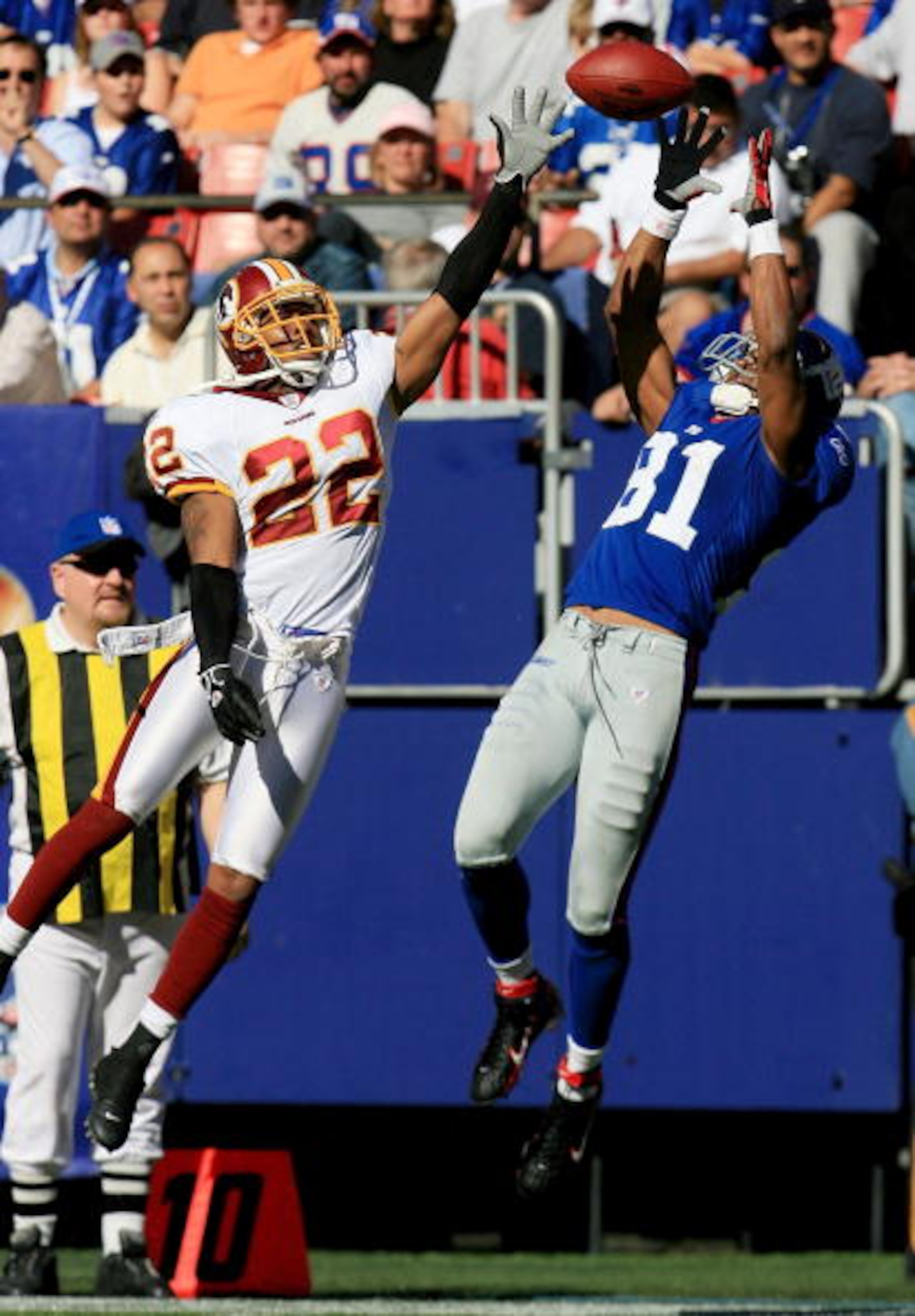 EAST RUTHERFORD, NJ - OCTOBER 08:  Amani Toomer #81 of the New York Giants hauls in a 21-yard pass in front of Carlos Rogers #22 of the Washington Redskins on October 8, 2006 at Giants Stadium in East Rutherford, New Jersey. The Giants defeated the Redski