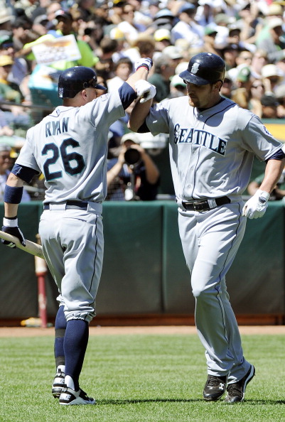 OAKLAND, CA - APRIL 3: Ryan Langerhans #12 of the Seattle Mariners after hitting a home run bashes forearms with teammate Brendan Ryan #26 against the Oakland Athletics during a MLB baseball game at the Oakland-Alameda County Coliseum April 3, 2011 in Oak