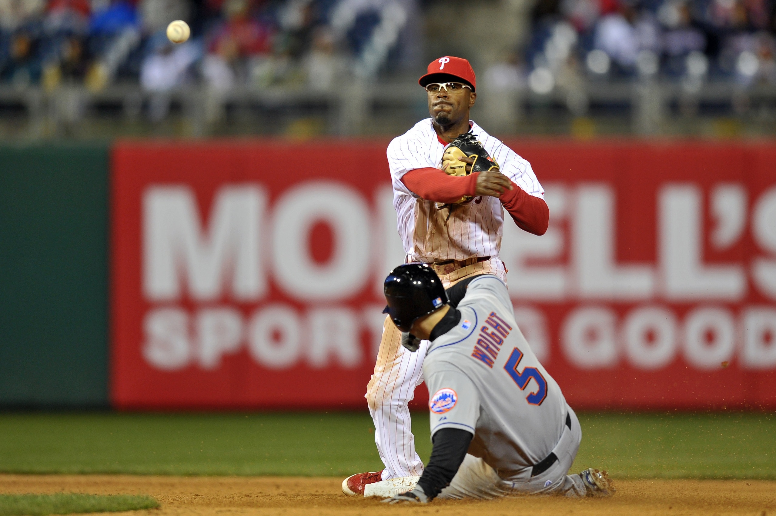 PHILADELPHIA, PA - APRIL 05: Jimmy Rollins #11 of the Philadelphia Phillies makes a throw to first for a double play after getting David Wright #5 of the New York Mets out at second base at Citizens Bank Park on April 5, 2011 in Philadelphia, Pennsylvania