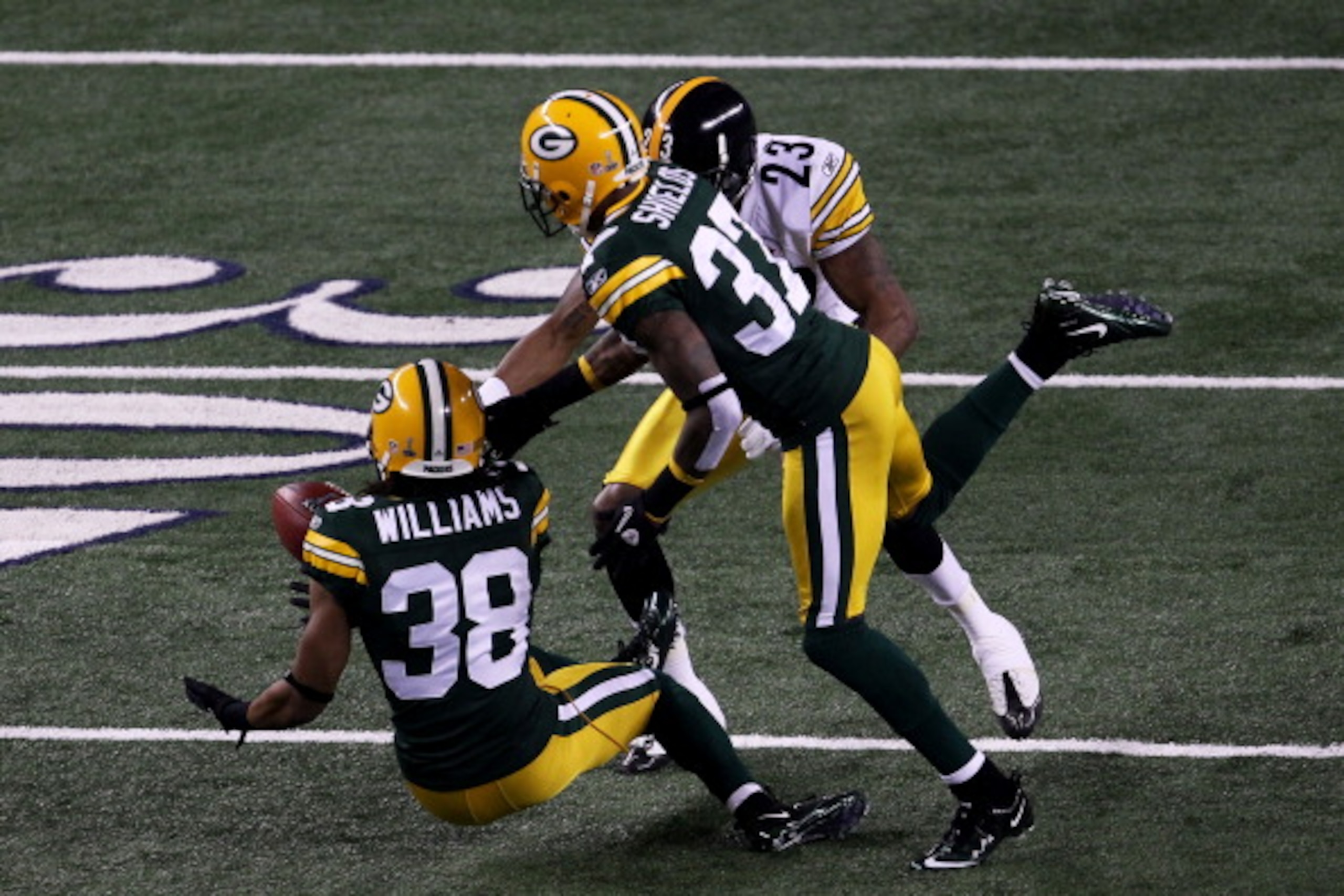 ARLINGTON, TX - FEBRUARY 06: Tramon Williams #38 of the Green Bay Packers muffs a punt as Sam Shields #37 and Keenan Lewis #23 of the Pittsburgh Steelers attempt to recover during Super Bowl XLV at Cowboys Stadium on February 6, 2011 in Arlington, Texas. ARLINGTON, TX - FEBRUARY 06: Tramon Williams #38 of the Green Bay Packers muffs a punt as Sam Shields #37 and Keenan Lewis #23 of the Pittsburgh Steelers attempt to recover during Super Bowl XLV at Cowboys Stadium on February 6, 2011 in Arlington, Texas.