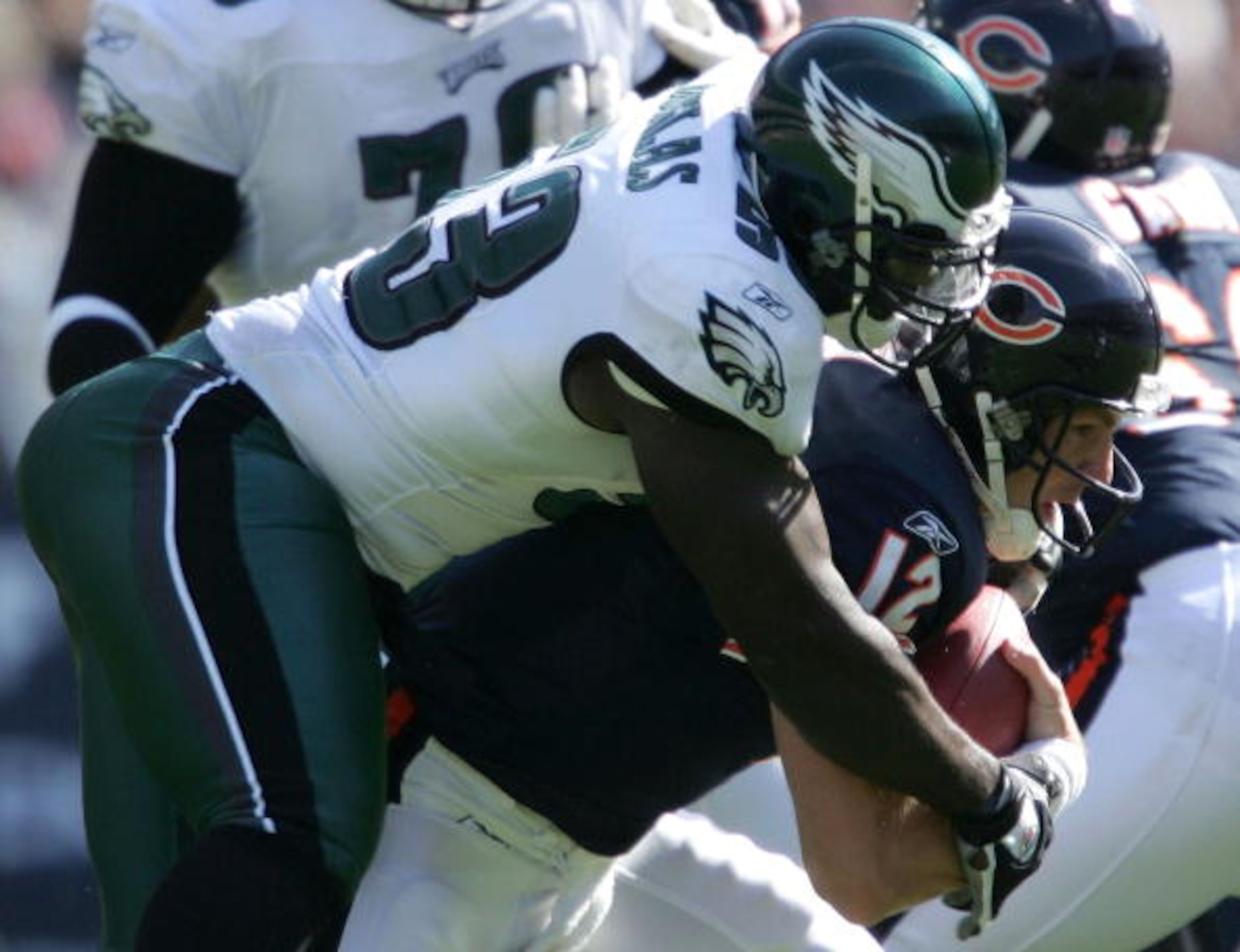 CHICAGO - OCTOBER 3:  Jonathan Quinn #12 of the Chicago Bears is sacked by Hugh Douglas #53 of the Philadelphia Eagles on October 3, 2004 at Soldier Field in Chicago, Illinois. The Philadelphia Eagles defeated the Chicago Bears 19-9.  (Photo by Elsa/Getty