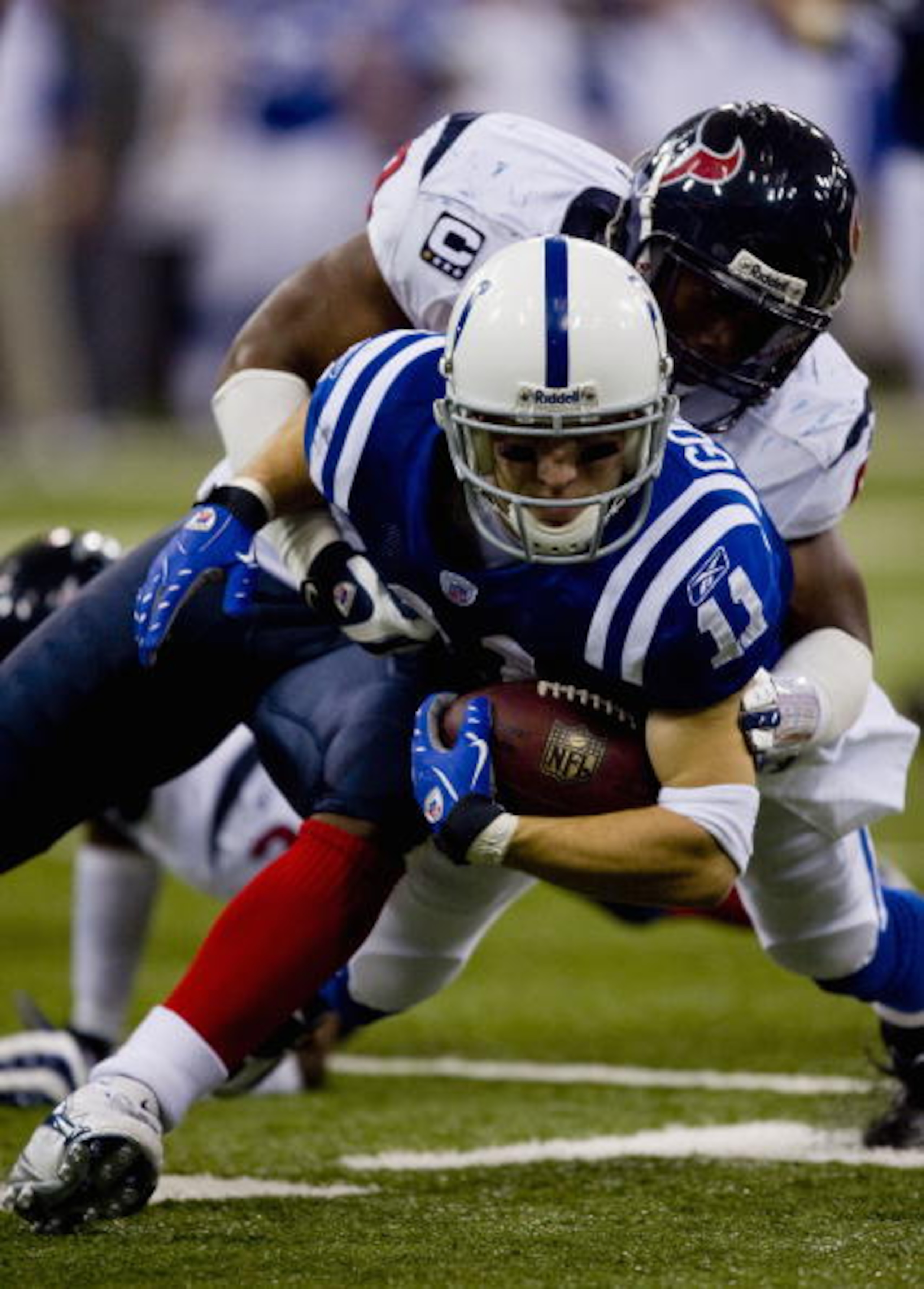 INDIANAPOLIS, IN - DECEMBER 23: Anthony Gonzalez #11 of the Indianapolis Colts is tackled by DeMeco Ryans #59 of the Houston Texans at the RCA Dome December 23, 2007 in Indianapolis, Indiana.  The Colts beat the Texans 38-15.  (Photo by Dilip Vishwanat/Ge