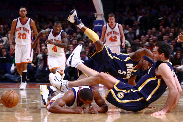 NEW YORK - JANUARY 02: T.J. Ford #5 of the Indiana Pacers and teammate Jeff Foster #10 dive over Chris Duhon #1 of the New York Knicks at Madison Square Garden January 2, 2009 in New York City. NOTE TO USER: User expressly acknowledges and agrees that, by