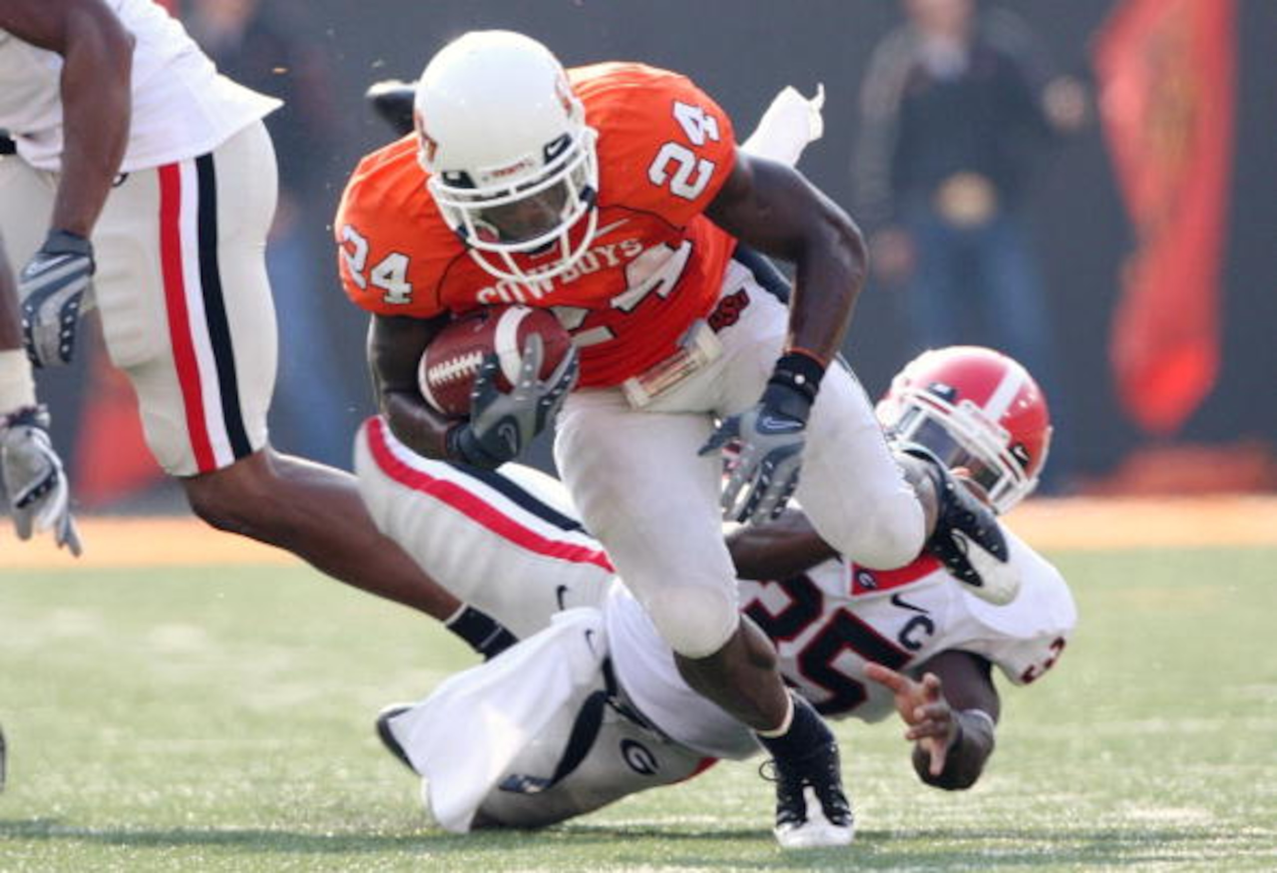 STILLWATER, OK - SEPTEMBER 5: Running back Kendall Hunter #24 of the Oklahoma State Cowboys carries the ball six yards as Rennie Curran #35 of the Georgia Bulldogs tries to stop him during the fourth quarter of the game at Boone Pickens Stadium on Septemb
