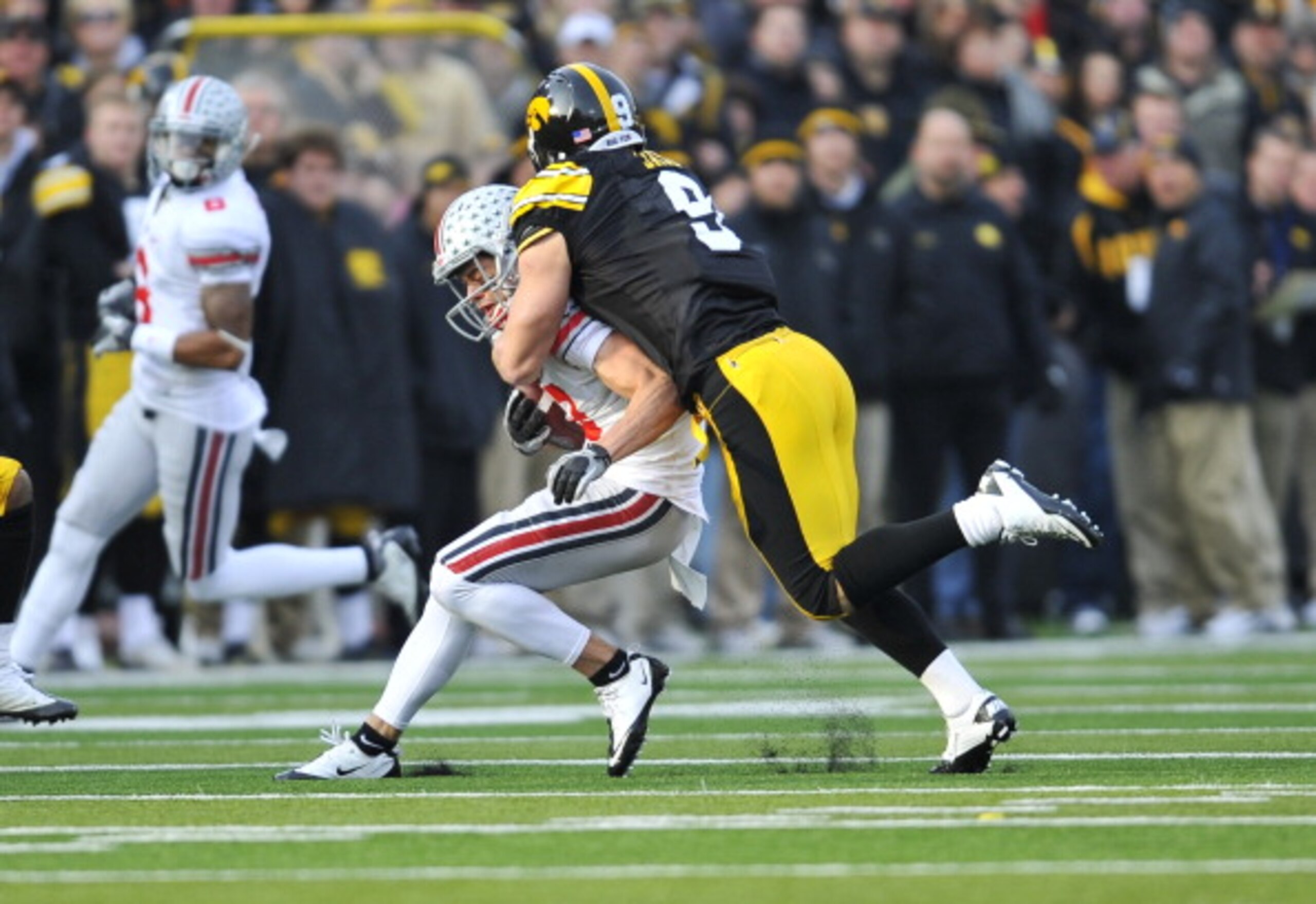 IOWA CITY, IA - NOVEMBER 20: Defensive back Tyler Sash #9 of the University of Iowa Hawkeyes tackles wide receiver Dane Sanzenbacher #12 of the Ohio State Buckeyes during the first half of play at Kinnick Stadium on November 20, 2010 in Iowa City, Iowa. O