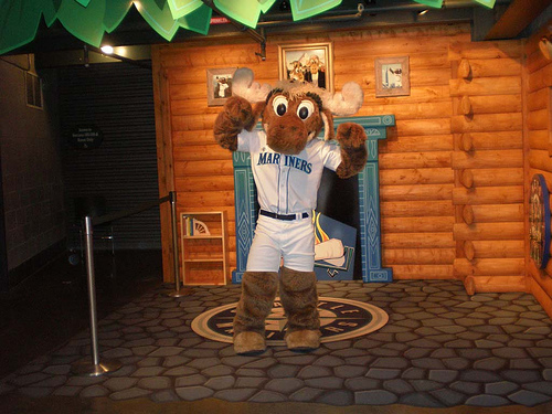 Moose, the Seattle Mariners mascot, wears a mask as he holds a sign that  reads Believe before a baseball game against the Los Angeles Angels,  Friday, Oct. 1, 2021, at T-Mobile Park