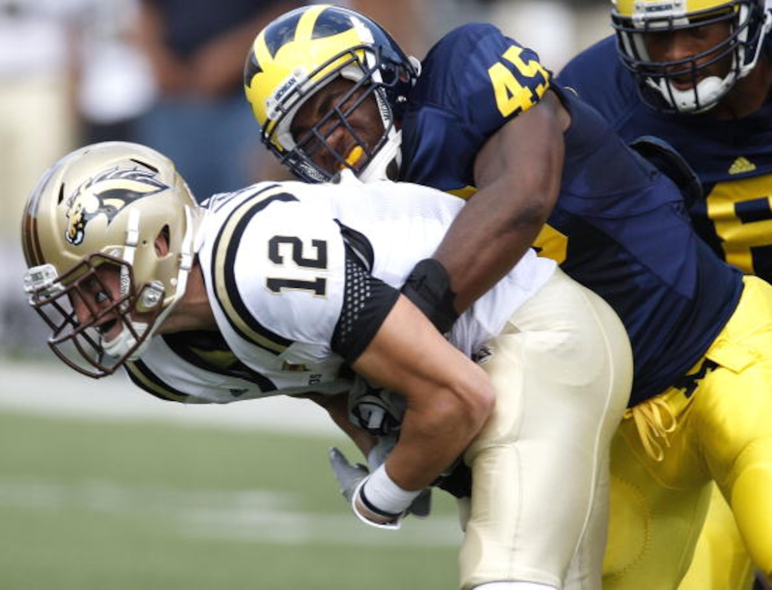 ANN ARBOR, MI - SEPTEMBER 5: Obi Ezeh #45 of the Michigan Wolverines tackles Robert Arnheim #12 of the Western Michigan Broncos during the game on September 5, 2009 at Michigan Stadium in Ann Arbor, Michigan. (Photo by Gregory Shamus/Getty Images) ANN ARBOR, MI - SEPTEMBER 5: Obi Ezeh #45 of the Michigan Wolverines tackles Robert Arnheim #12 of the Western Michigan Broncos during the game on September 5, 2009 at Michigan Stadium in Ann Arbor, Michigan. (Photo by Gregory Shamus/Getty Images)