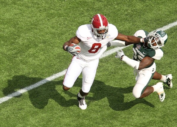 ORLANDO, FL - JANUARY 01: Julio Jones #8 of the Alabama Crimson Tide stiffarms Chris Rucker #29 of  the Michigan State Spartans during the Capitol One Bowl at the Florida Citrus Bowl on January 1, 2011 in Orlando, Florida.  (Photo by Mike Ehrmann/Getty Im