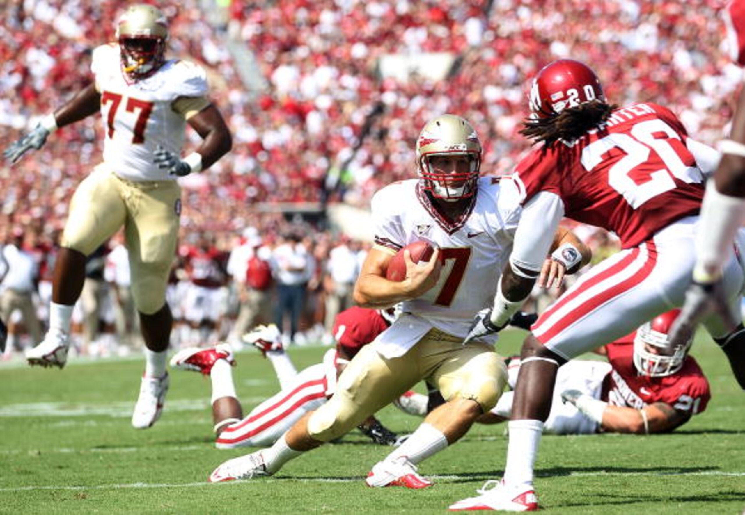NORMAN, OK - SEPTEMBER 11:  Quarterback Christian Ponder #7 of the Florida State Seminoles runs the ball against Quinton Carter #20 of the Oklahoma Sooners at Gaylord Family Oklahoma Memorial Stadium on September 11, 2010 in Norman, Oklahoma.  (Photo by R
