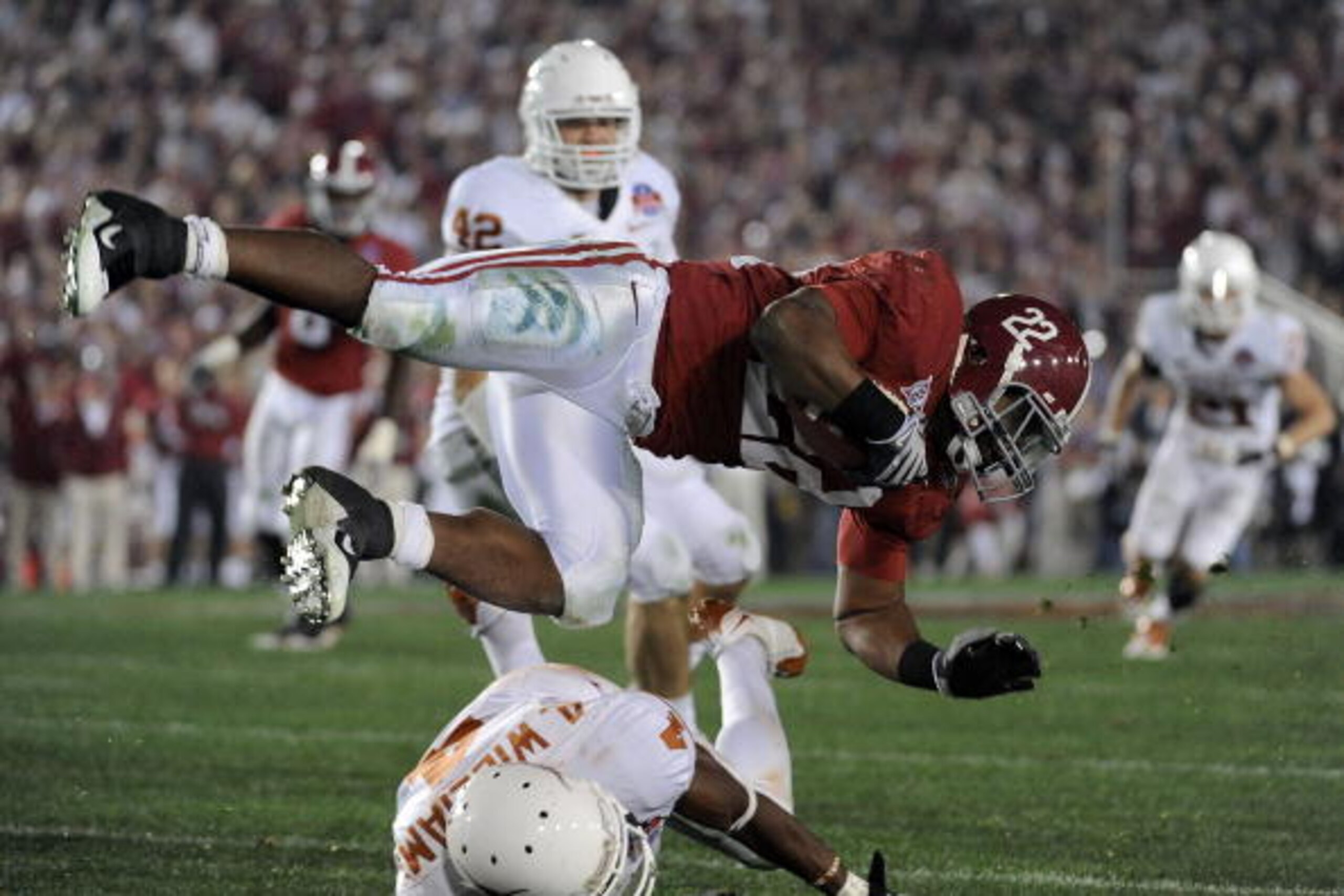 PASADENA, CA - JANUARY 07:  Running back Mark Ingram #22 of the Alabama Crimson Tide is tackled by cornerback Aaron Williams #4 of the Texas Longhorns during the Citi BCS National Championship game at the Rose Bowl on January 7, 2010 in Pasadena, Californ