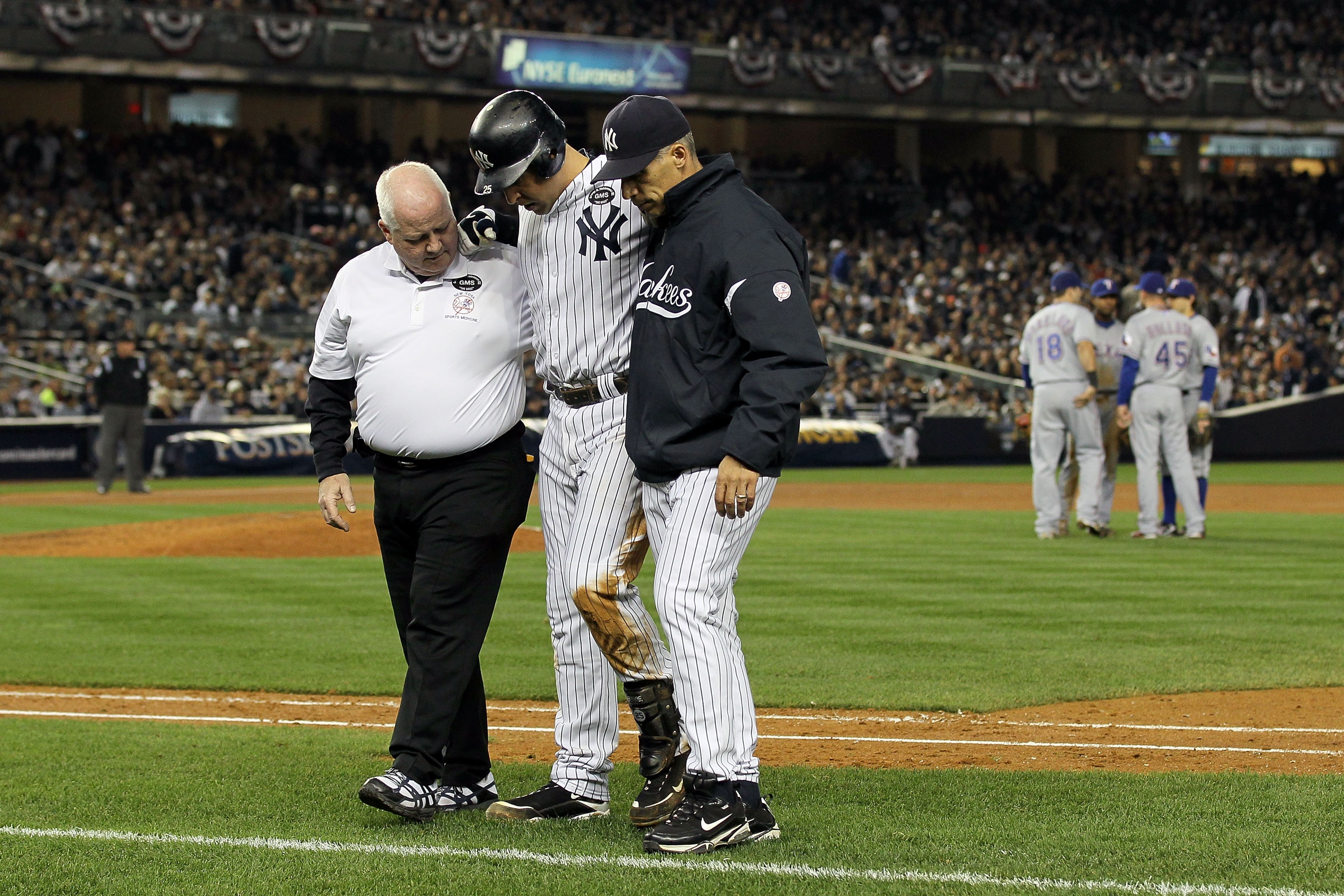NEW YORK - OCTOBER 19:  Mark Teixeira #25 of the New York Yankees is helped off of the field by Manager Joe Girardi and a trainer after hurting himself while playing against the Texas Rangers in Game Four of the ALCS during the 2010 MLB Playoffs at Yankee