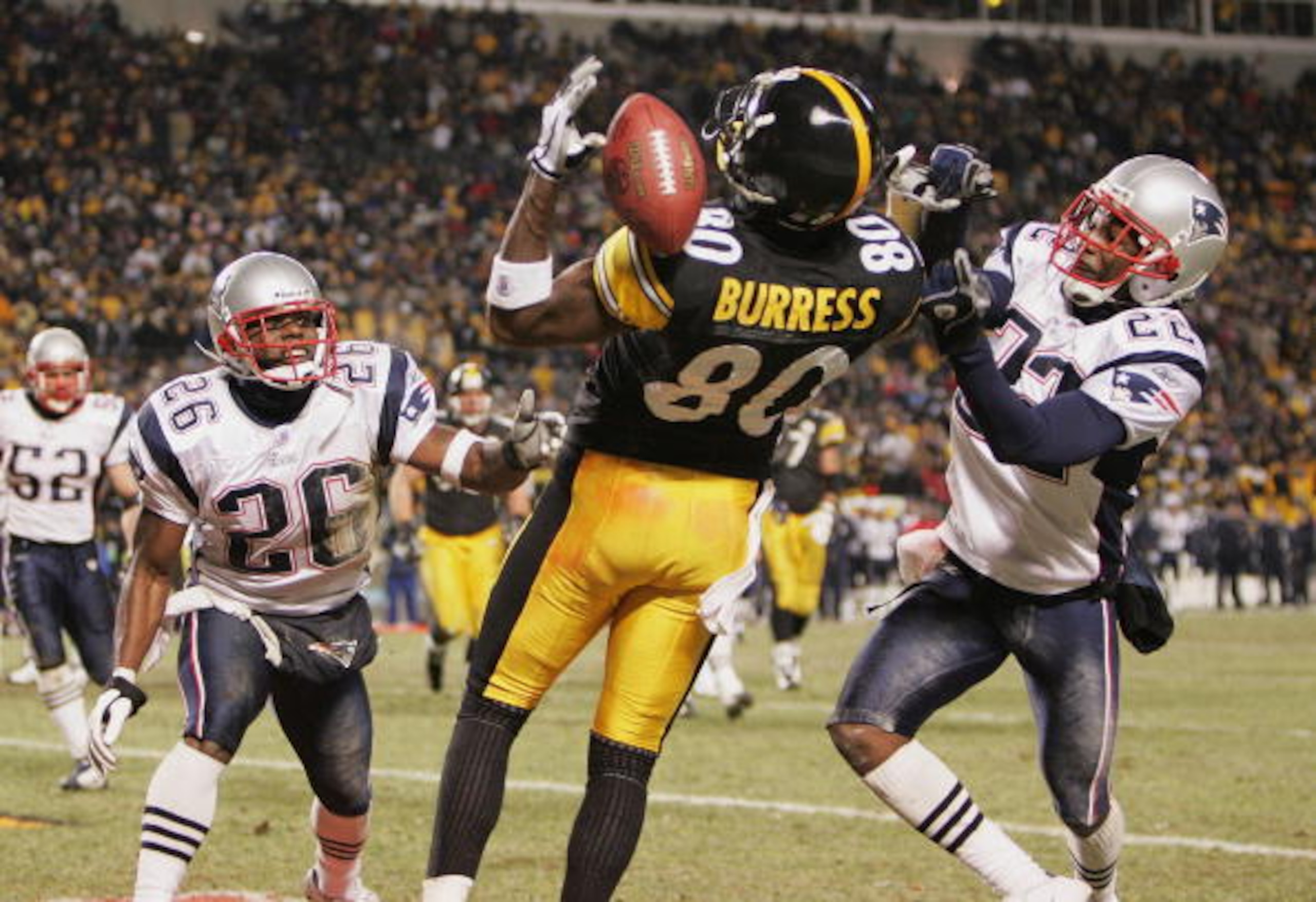 PITTSBURGH - JANUARY 23:  Defensive backs Eugene Wilson #26 and Asante Samuel #22 of the New England Patriots defend as a pass goes through the hands of wide receiver Plaxico Burress #80 of the Pittsburgh Steelers in the AFC championship game at Heinz Fie