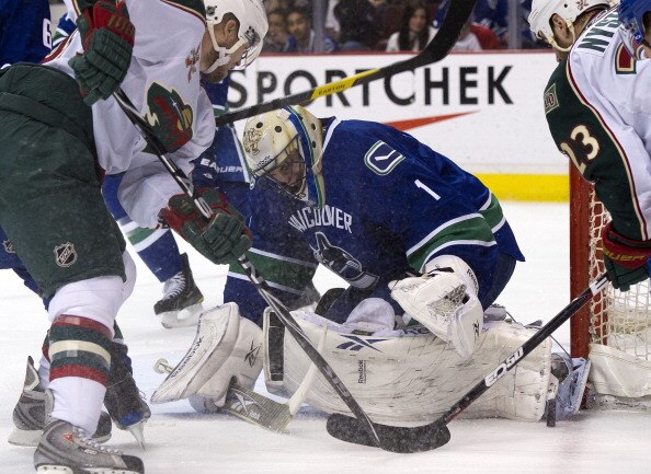 VANCOUVER, CANADA - APRIL 7: Goalie Roberto Luongo #1of the Vancouver Canucks looks for the loose puck while Brad Staubitz #16 and Eric Nystrom #23 of the Minnesota Wild tries to jam it in during the first period in NHL action on April 07, 2011 at Rogers