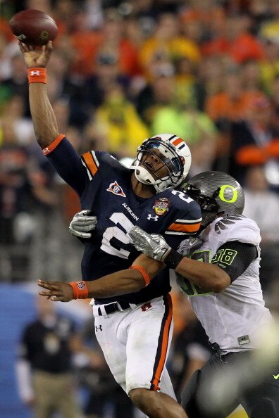 GLENDALE, AZ - JANUARY 10:  Cameron Newton #2 of the Auburn Tigers tries to pass as Kenny Rowe #58 of the Oregon Ducks tries to tackle him during the Tostitos BCS National Championship Game at University of Phoenix Stadium on January 10, 2011 in Glendale,