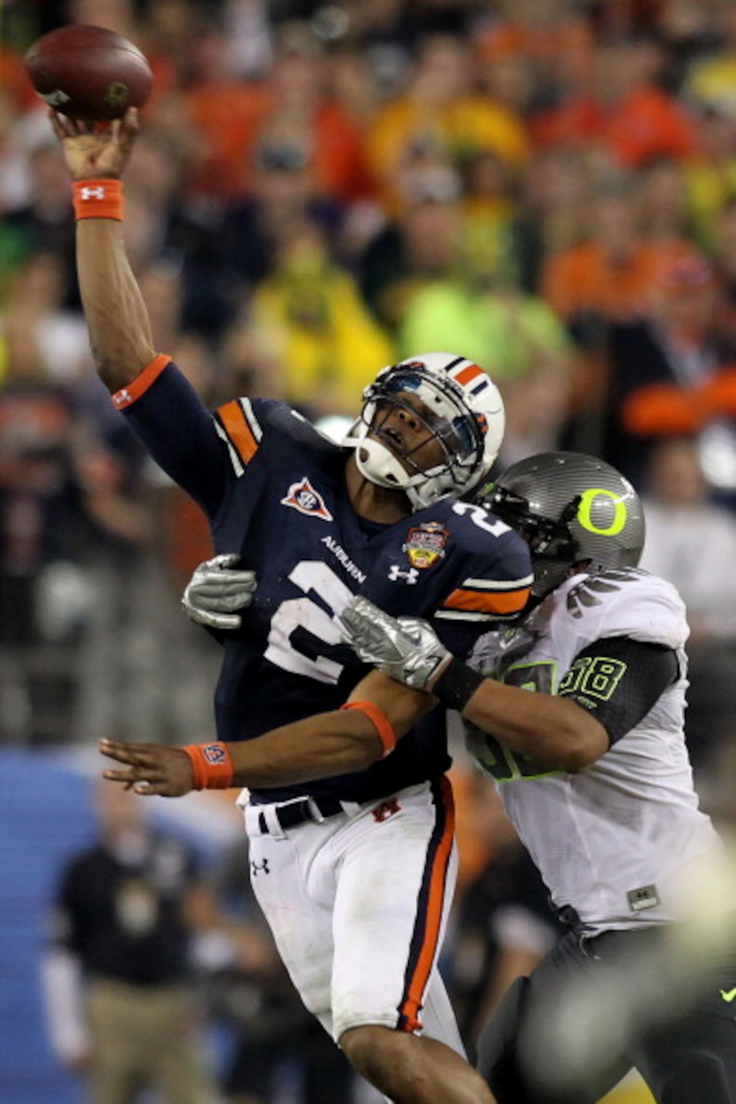 GLENDALE, AZ - JANUARY 10:  Cameron Newton #2 of the Auburn Tigers tries to pass as Kenny Rowe #58 of the Oregon Ducks tries to tackle him during the Tostitos BCS National Championship Game at University of Phoenix Stadium on January 10, 2011 in Glendale,
