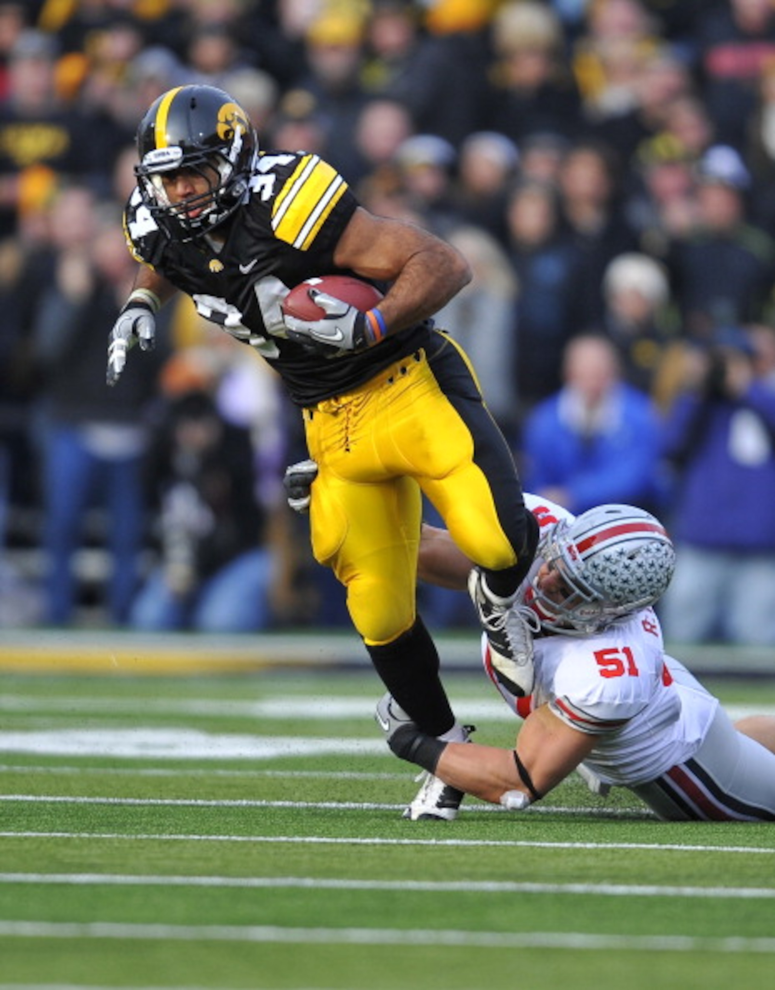 IOWA CITY, IA - NOVEMBER 20: Running back Marcus Coker #34 of the University of Iowa Hawkeyes is tackled by linebacker Ross Homan #51 of the Ohio State Buckeyes during the first half of play at Kinnick Stadium on November 20, 2010 in Iowa City, Iowa. Ohi IOWA CITY, IA - NOVEMBER 20: Running back Marcus Coker #34 of the University of Iowa Hawkeyes is tackled by linebacker Ross Homan #51 of the Ohio State Buckeyes during the first half of play at Kinnick Stadium on November 20, 2010 in Iowa City, Iowa. Ohi