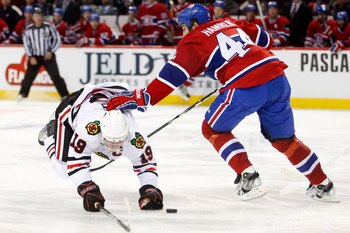 MONTREAL, CANADA - APRIL 5:  Roman Hamrlik #44 of the Montreal Canadiens takes down Jonathan Toews #19 of the Chicago Blackhawks during the NHL game at the Bell Centre on April 5, 2011 in Montreal, Quebec, Canada.  The Canadiens defeated the Blackhawks 2-