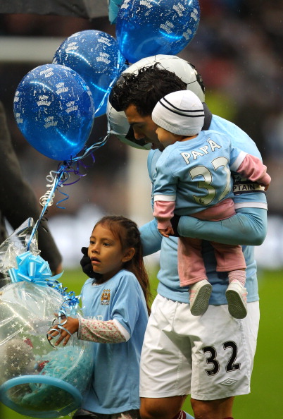 MANCHESTER, ENGLAND - FEBRUARY 05:  Carlos Tevez of Manchester City lines up with his children Florencia and Katia while holding balloons to celebrate his birthday prior to the Barclays Premier League match between Manchester City and West Bromwich Albion