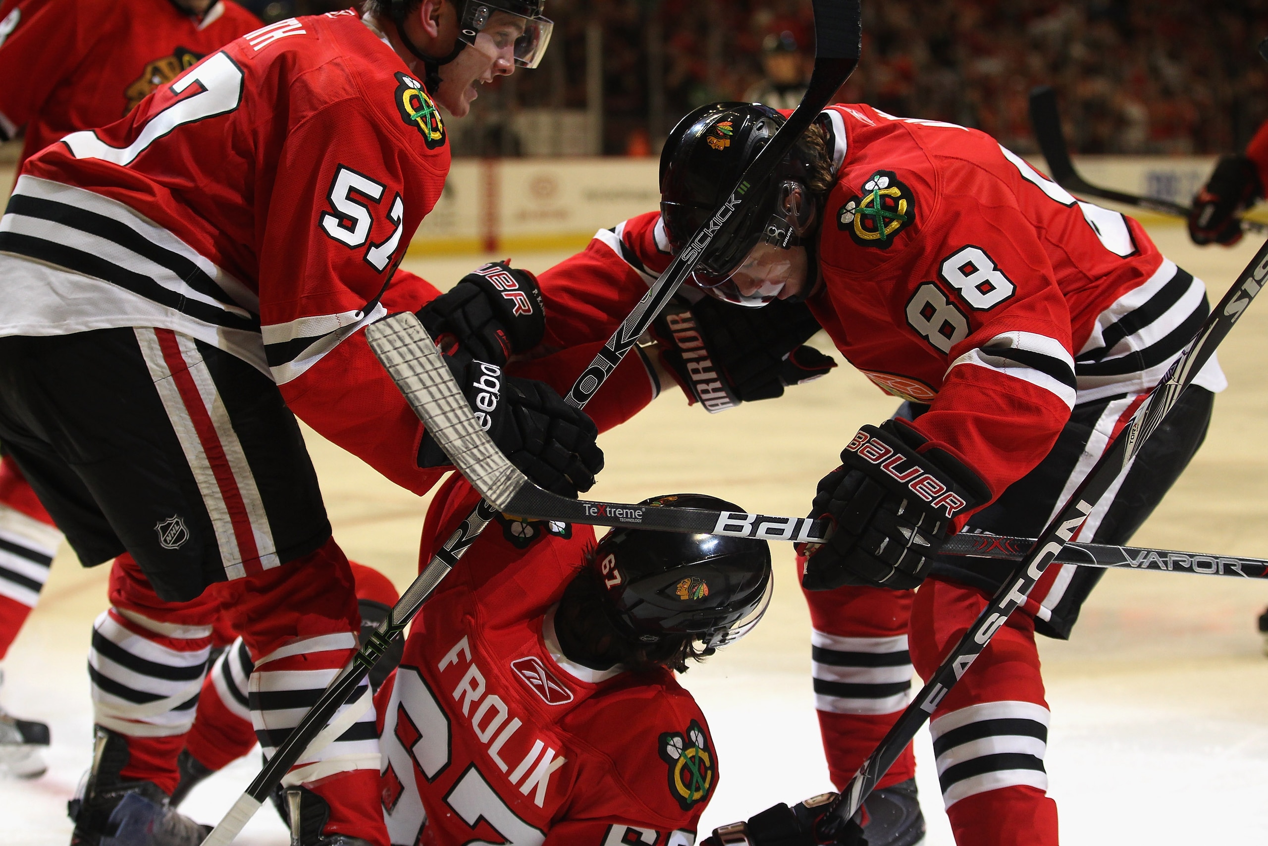 CHICAGO, IL - APRIL 10: Michael Frolik #67 of the Chicago Blackhawks is congratulated by teammates Ben Smith #57 and Patrick Kane #88 after scoring a goal in the 2nd period against the Detroit Red Wings at the United Center on April 10, 2011 in Chicago, I