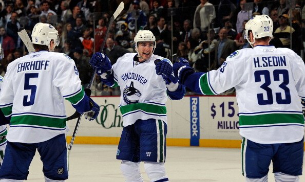 NASHVILLE, TN - MARCH 29:  Christian Ehrhoff #5 and Henrik Sedin #33 of the Vancouver Canucks congratulate teammate Alexandre Burrows #14 on scoring a goal against the Nashville Predators on March 29, 2011 at the Bridgestone Arena in Nashville, Tennessee.