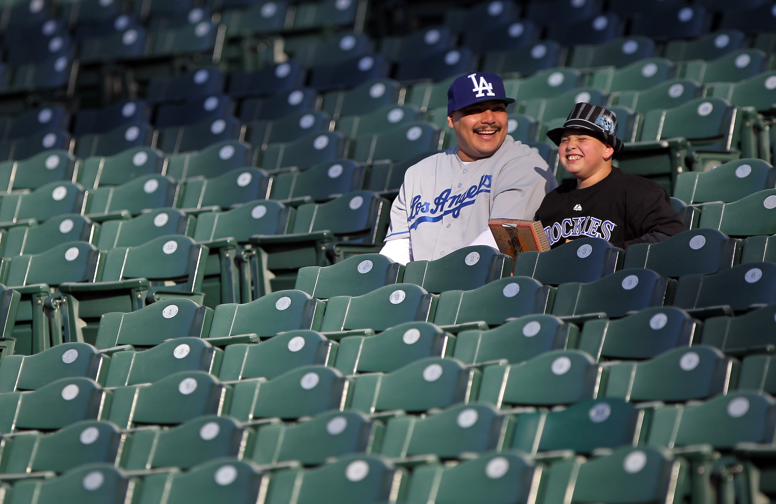 DENVER, CO - APRIL 05:  Michael Guerro (L) and his son Isaiah Alvarez, 10, get early seats as their prepare to support their teams as the Colorado Rockies host the Los Angeles Dodgers at Coors Field on April 5, 2011 in Denver, Colorado.  (Photo by Doug Pe