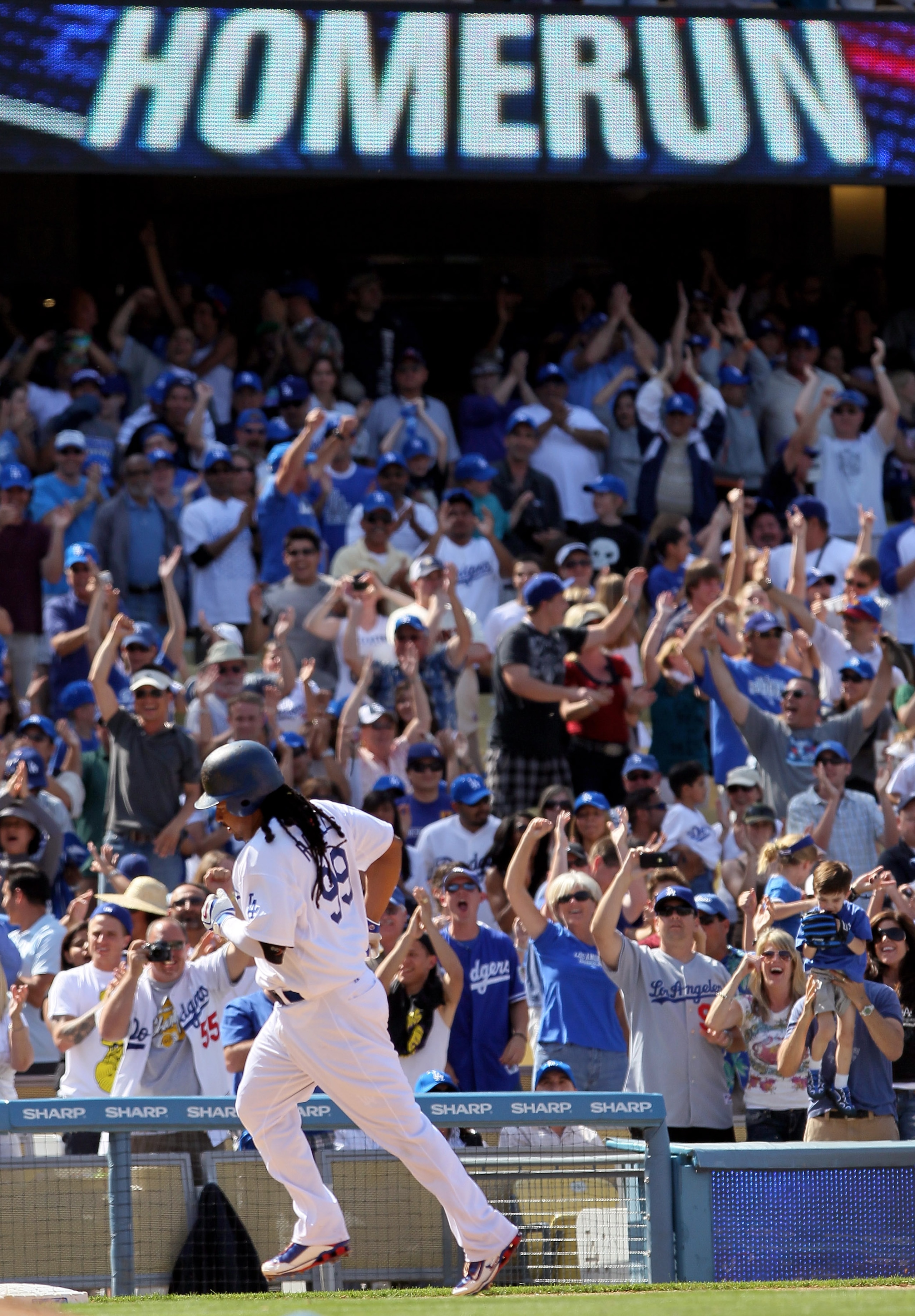 LOS ANGELES, CA - APRIL 18:  Fans celebrate as Manny Ramirez #99 of the Los Angeles Dodgers rounds third base after hitting a two-run homerun in the eighth inning against the San Francisco Giants at Dodger Stadium on April 18, 2010 in Los Angeles, Califor