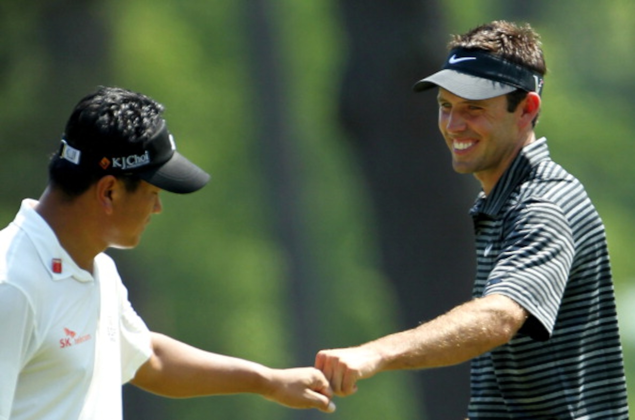 AUGUSTA, GA - APRIL 10:  Charl Schwartzel of South Africa (R) celebrates with K.J. Choi of South Korea after Schwartzel holed a shot for eagle on the third green during the final round of the 2011 Masters Tournament on April 10, 2011 in Augusta, Georgia.