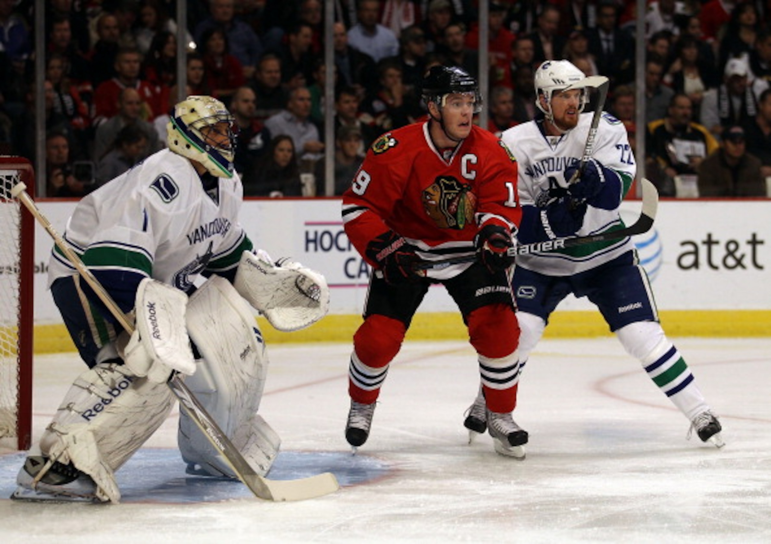 CHICAGO - OCTOBER 20: Jonathan Toews #19 of the Chicago Blackhawks awaits a pass between Roberto Luongo #1 (L) and Daniel Sedin #22 of the Vancouver Canucks at the United Center on October 20, 2010 in Chicago, Illinois. The Blackhawks defeated the Canucks