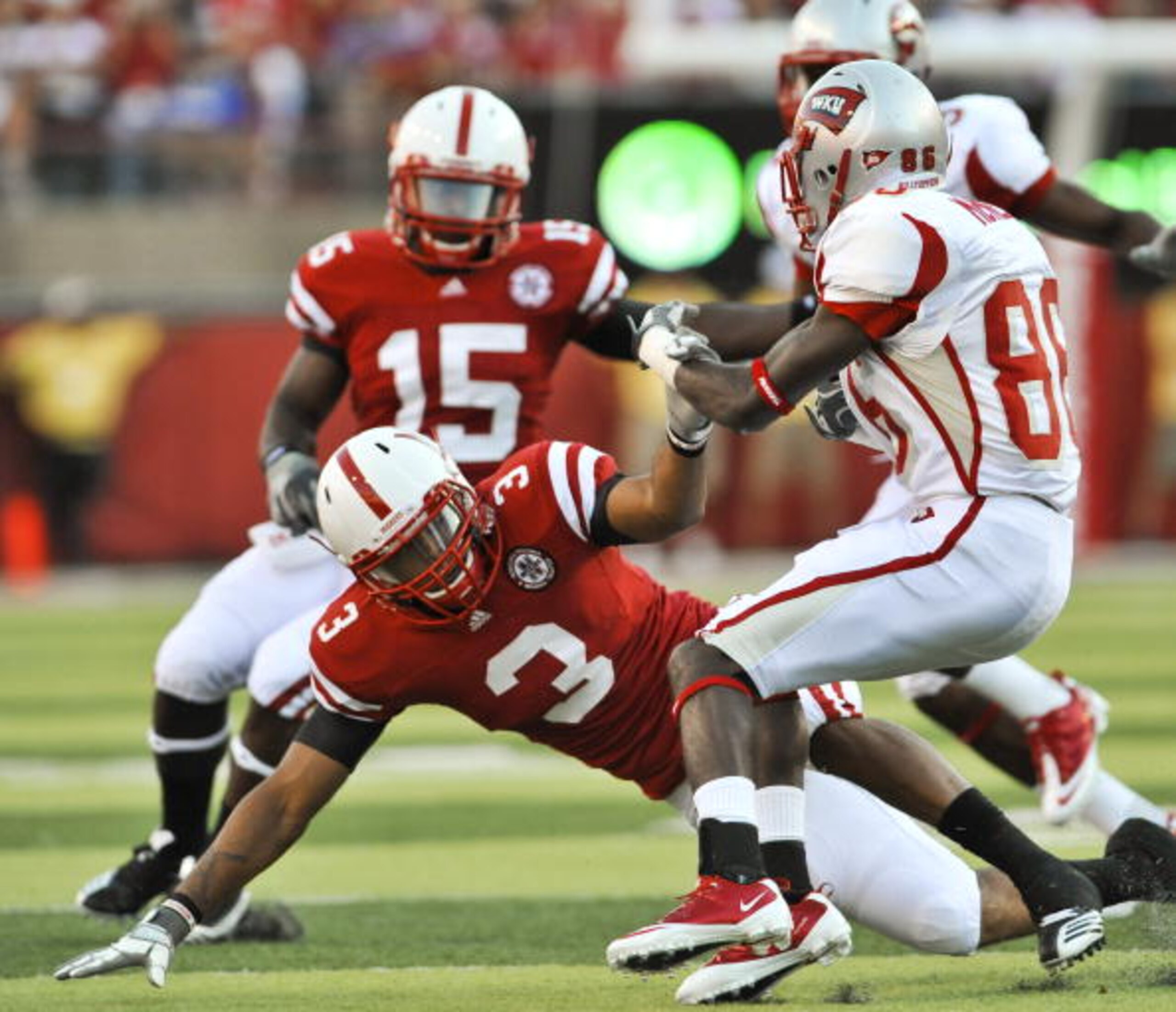 LINCOLN, NE - SEPTEMBER 04:  Willie McNeal #86 of the Western Kentucky Hilltoppers trys to avoid being brought down by Ricky Thenarse #3 of the Nebraska Cornhuskers during first half action of their game at Memorial Stadium on September 4, 2010 in Lincoln