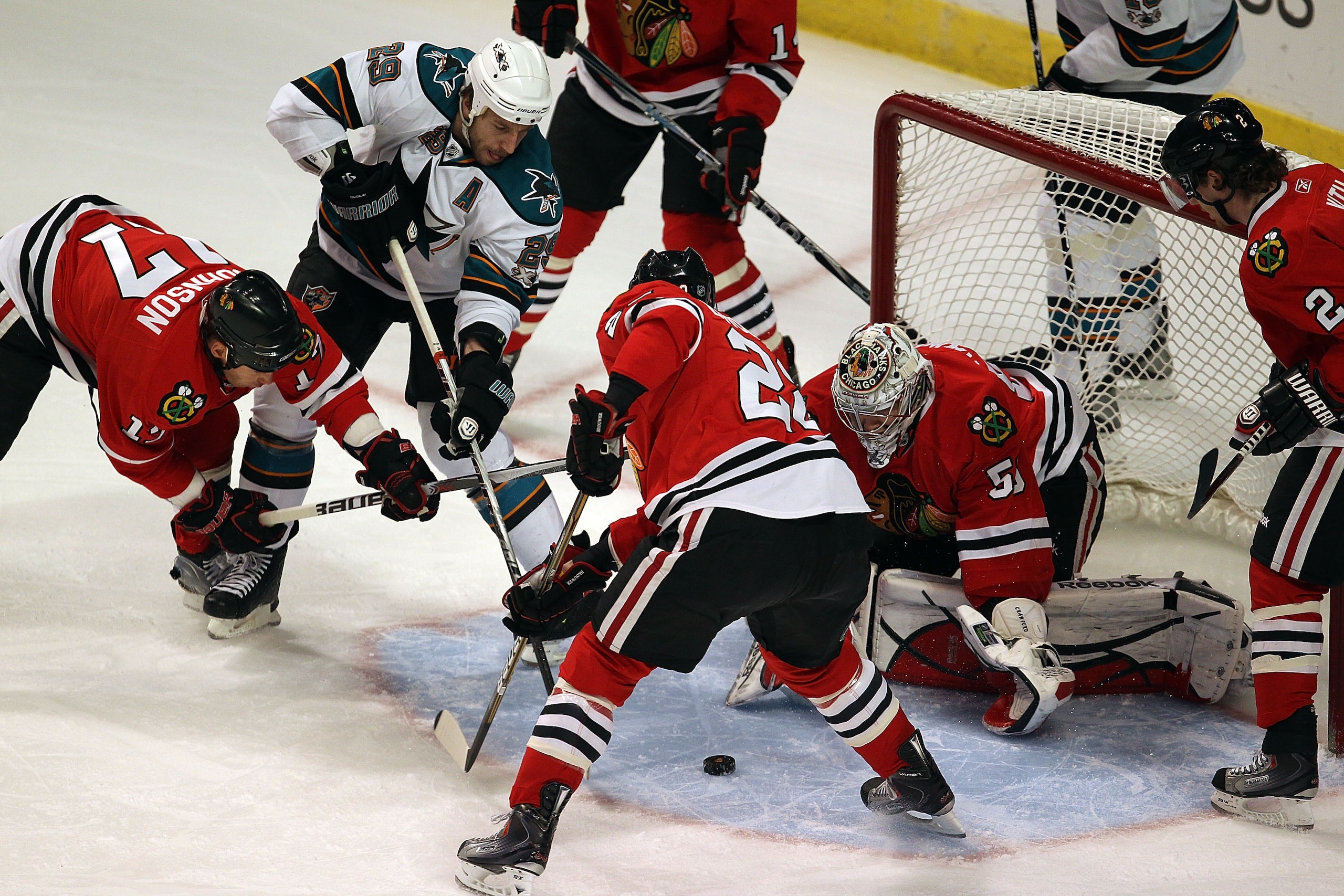 CHICAGO, IL - MARCH 14: Corey Crawford #50 of the Chicago Blackhawks makes a save as teammates Ryan Johnson #17 and Troy Brouwer #22 defend against a shot by Ryane Clowe #29 of the San Jose Sharks at the United Center on March 14, 2011 in Chicago, Illinoi