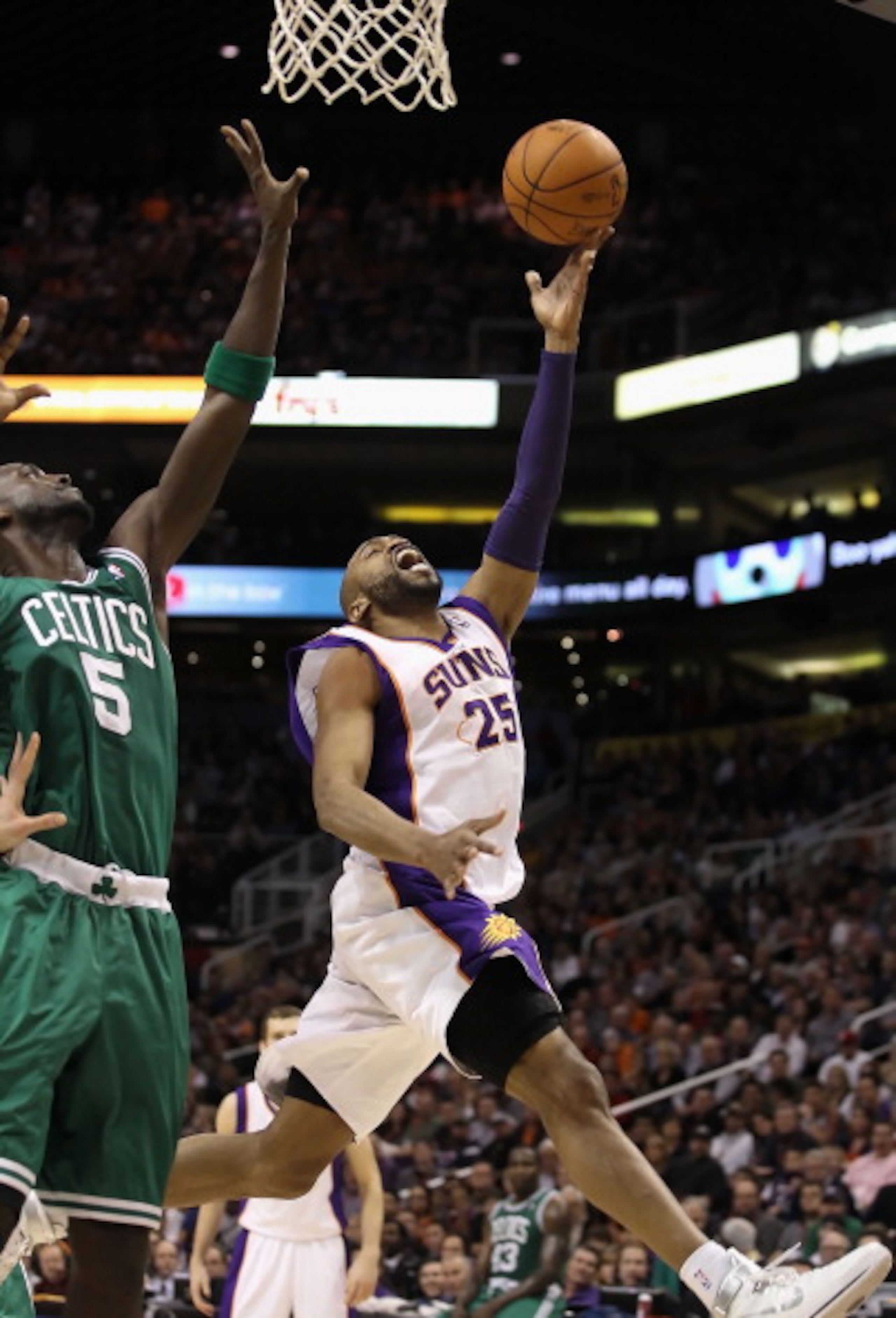 PHOENIX, AZ - JANUARY 28:  Vince Carter #25 of the Phoenix Suns lays up a shot past Kevin Garnett #5 of the Boston Celtics during the NBA game at US Airways Center on January 28, 2011 in Phoenix, Arizona.  The Suns defeated the Celtics 88-71. NOTE TO USER