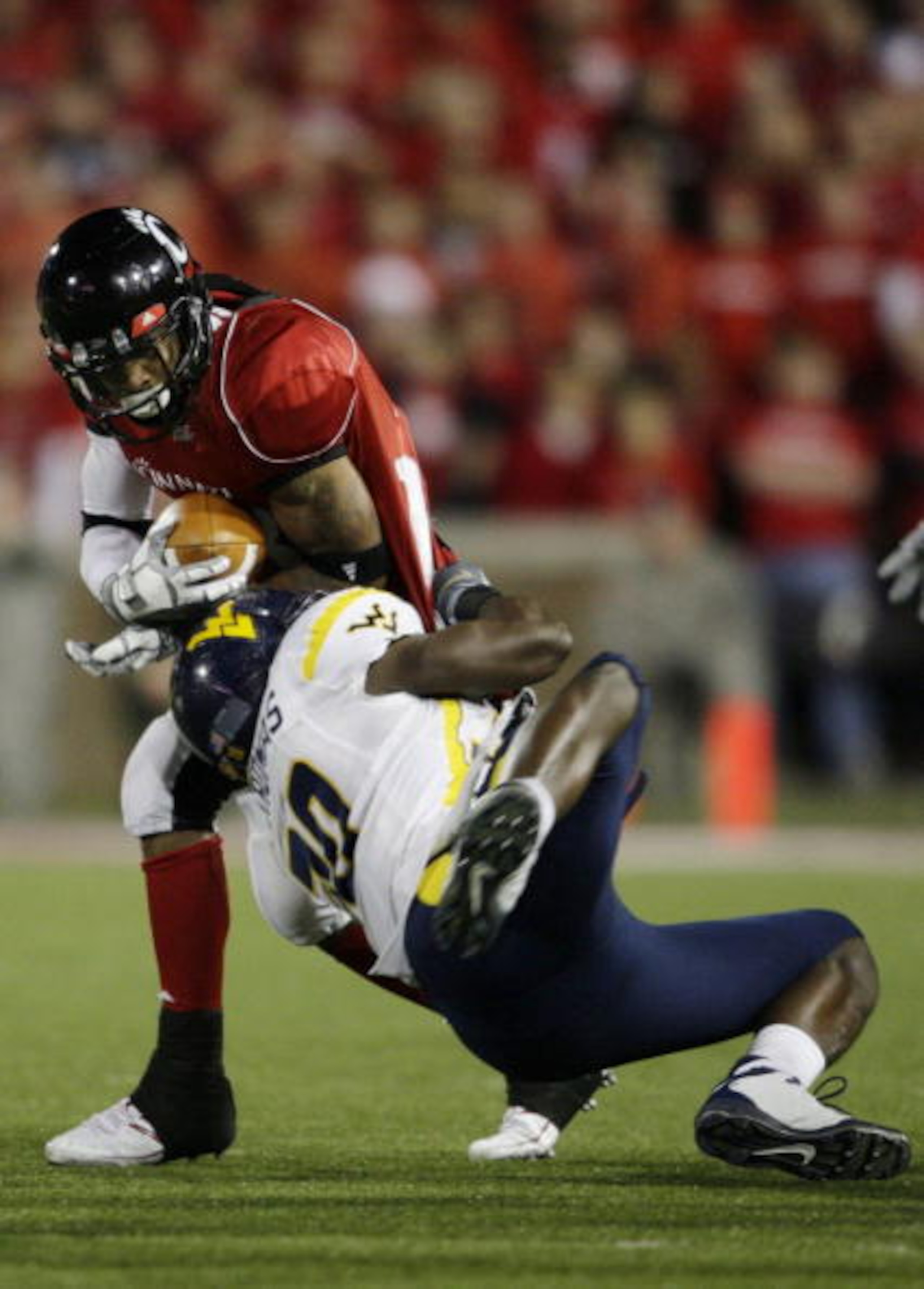 CINCINNATI - NOVEMBER 13: Isaiah Pead #23 of the Cincinnati Bearcats is tackled by J.T. Thomas #30 of the West Virginia Mountaineers during the third quarter of the game at Nippert Stadium on November 13, 2009 in Cincinnati, Ohio. (Photo by Andy Lyons/Ge CINCINNATI - NOVEMBER 13: Isaiah Pead #23 of the Cincinnati Bearcats is tackled by J.T. Thomas #30 of the West Virginia Mountaineers during the third quarter of the game at Nippert Stadium on November 13, 2009 in Cincinnati, Ohio. (Photo by Andy Lyons/Ge