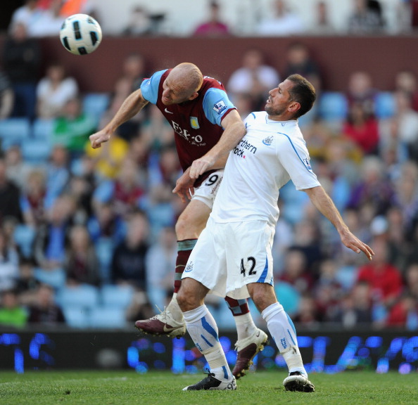 BIRMINGHAM, ENGLAND - APRIL 10:  James Collins of Aston Villa and Shefki Kuqi of Newcastle United battle for the ball during the Barclays Premier League match between Aston Villa and Newcastle United at Villa Park on April 10, 2011 Birmingham, England.  (