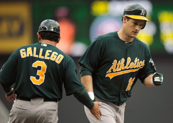 MINNEAPOLIS, MN - APRIL 10: Third base coach Mike Gallegro #3 of the Oakland Athletics congratulates Josh Willingham #16 as he rounds the bases following a solo home run off of Scott Baker #30 of the Minnesota Twins during the fourth inning of their game