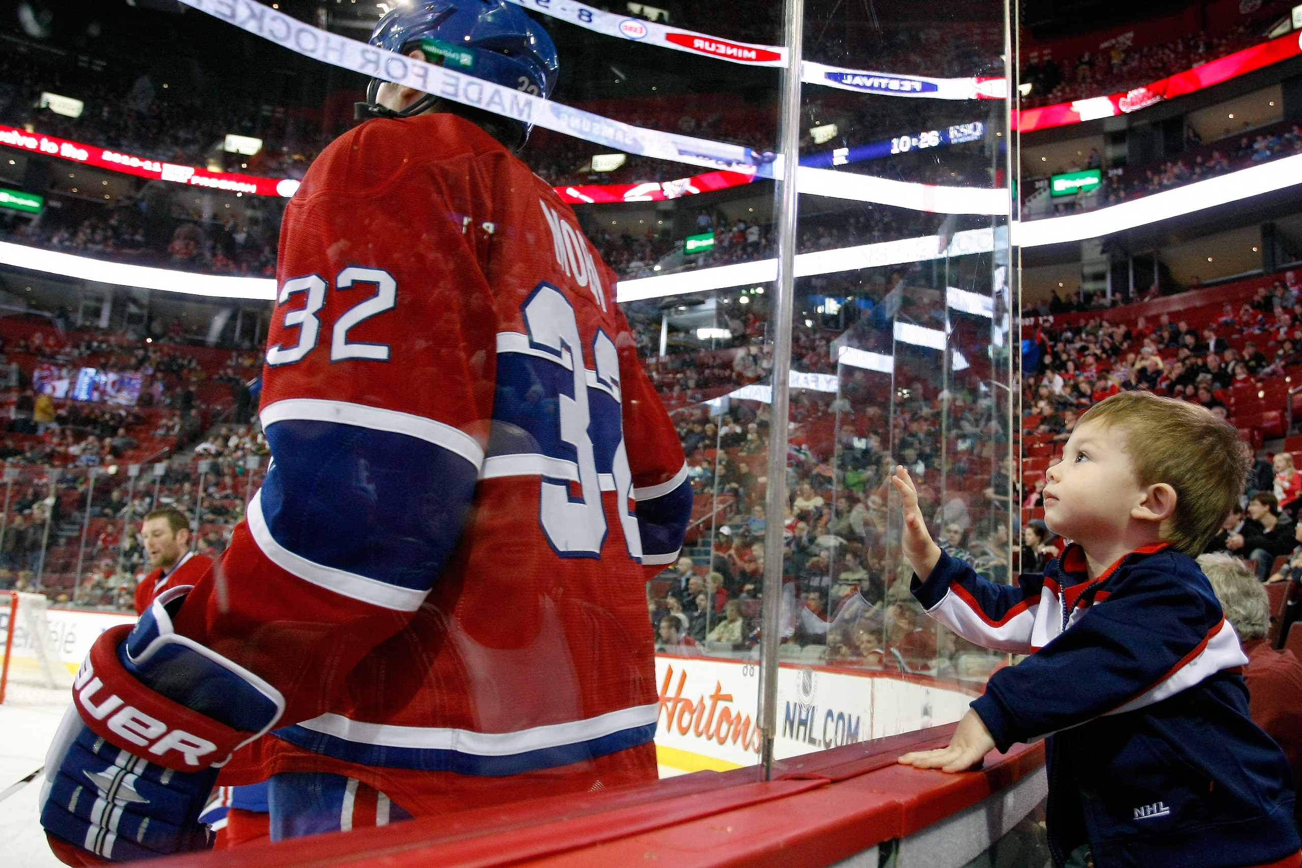 MONTREAL, CANADA - JANUARY 8:  A young male fan watches Travis Moen #32 of the Montreal Canadiens warm up prior to facing the Boston Bruins in their NHL game at the Bell Centre on January 8, 2011 in Montreal, Quebec, Canada.  (Photo by Richard Wolowicz/Ge