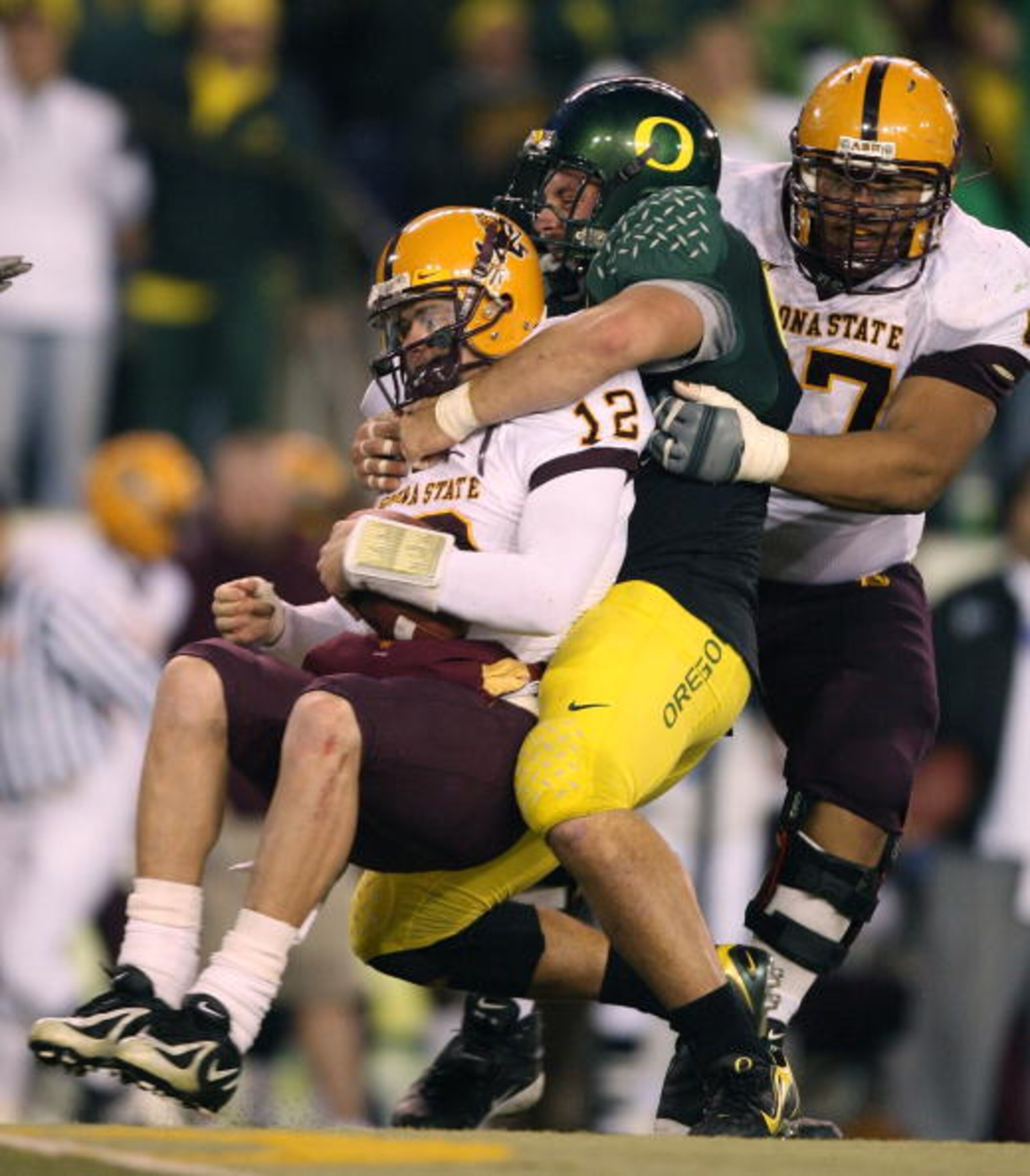 EUGENE, OR - NOVEMBER 03:  Quarterback Rudy Carpenter #12 of the Arizona State Sun Devils is sacked by Nick Reed #49 of the Oregon Ducks at Autzen Stadium on November 3, 2007 in Eugene, Oregon. The Ducks defeated the Sun Devils 35-23. (Photo by Otto Greul