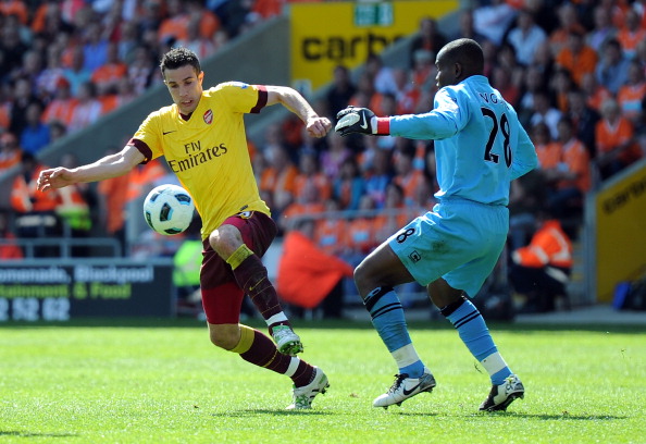 BLACKPOOL, ENGLAND - APRIL 10: Robin Van Persie of Arsenal takes the ball around Richard Kingson of Blackpool during the Barclays Premier League match between Blackpool and Arsenal at Bloomfield Road on April 10, 2011 in Blackpool, England.  (Photo by Chr