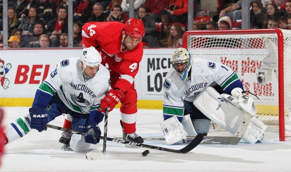 DETROIT, MI - DECEMBER 22:  Roberto Luongo #1 and Aaron Rome #29  of the Vancouver Canucks stop a scoring attempt by Todd Bertuzzi #44 of the Detroit Red Wings on December 22, 2010 at the Joe Louis Arena in Detroit, Michigan. The Wings defeated the Canuck