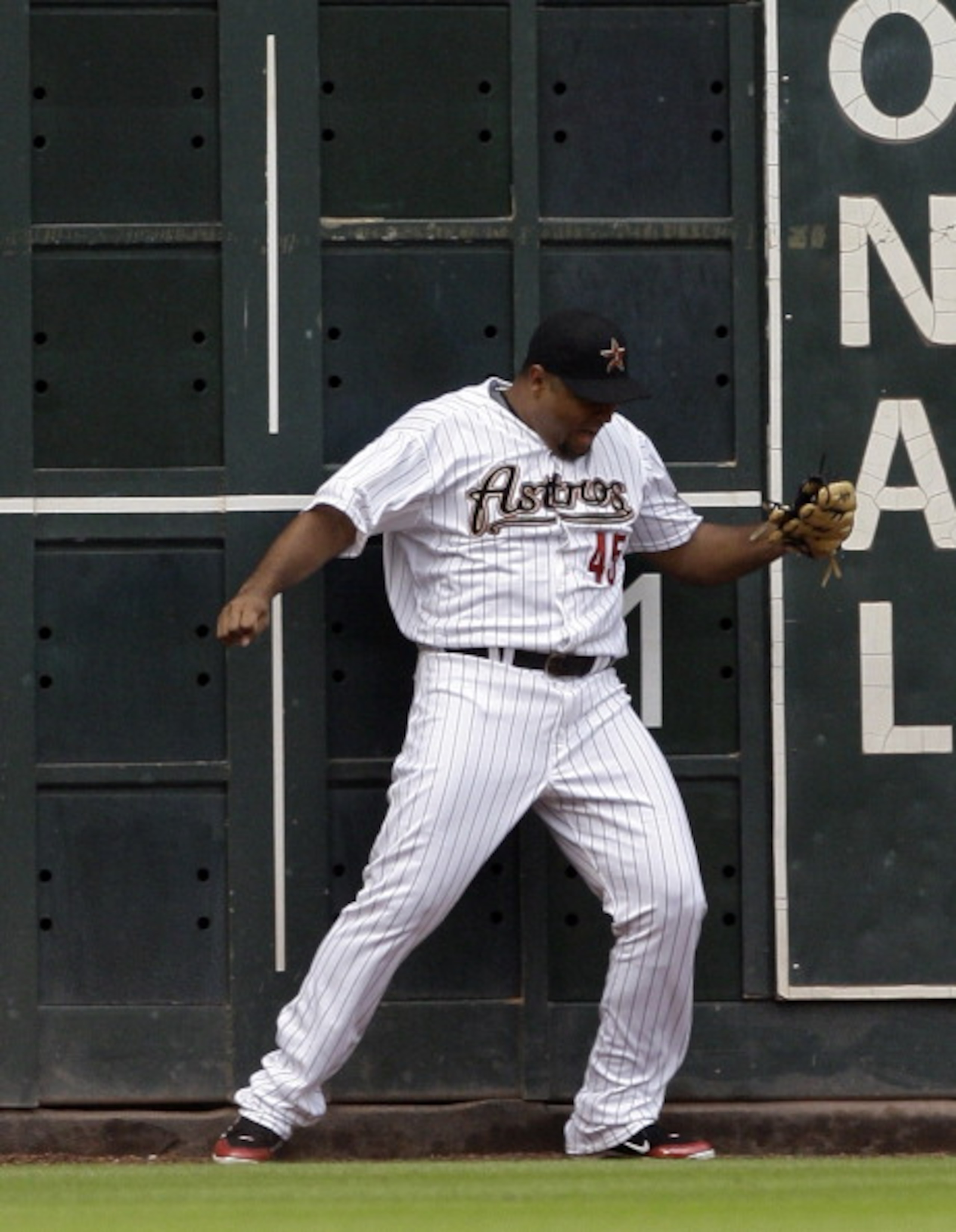 HOUSTON - APRIL 08:  Left fielder Carlos Lee #45 of the Houston Astros makes a catch at the fence in the first inning against the Florida Marlins at Minute Maid Park on April 8, 2011 in Houston, Texas. Lee was injured on the play but remained in the game.