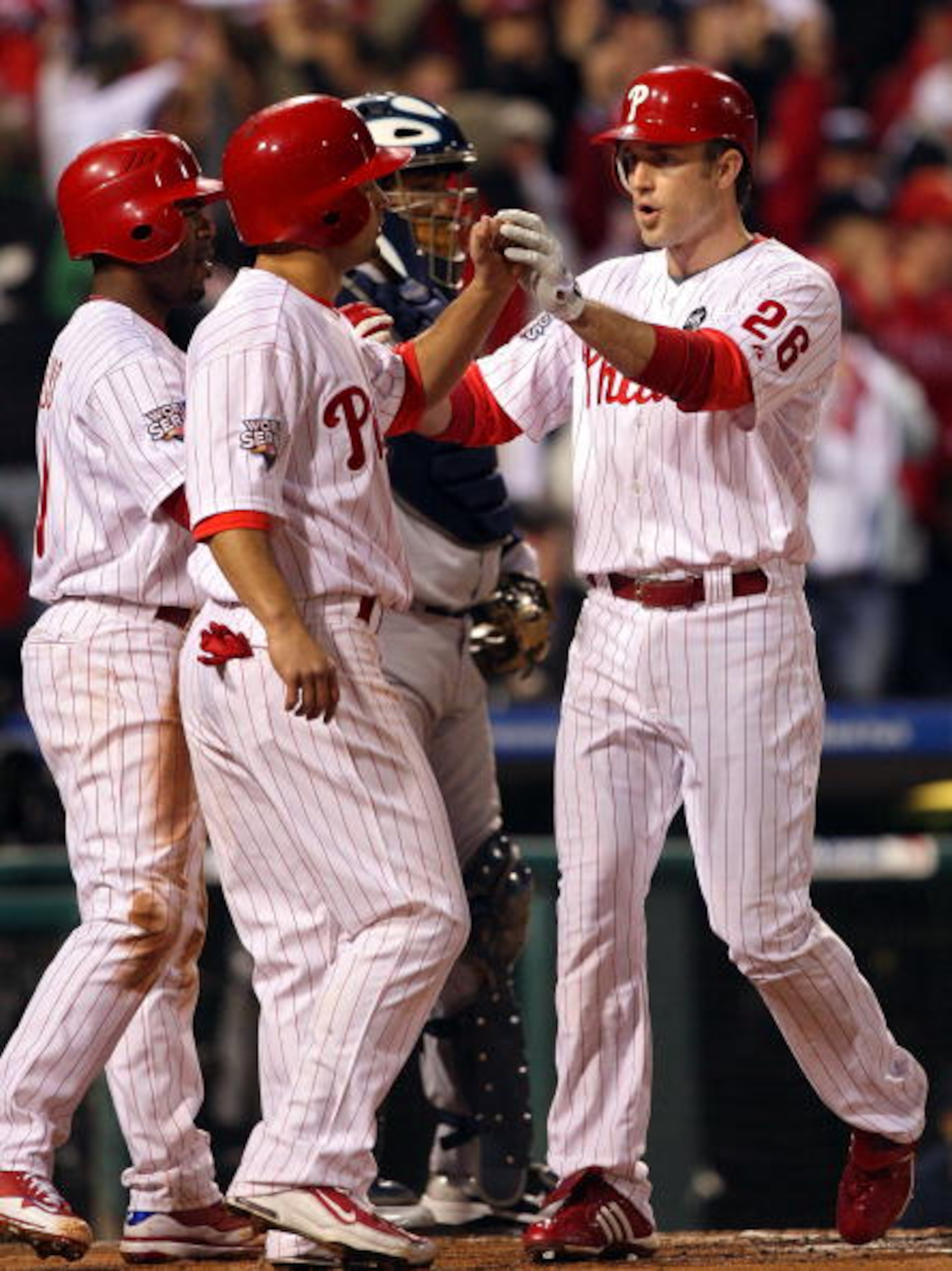 PHILADELPHIA - NOVEMBER 02:  (L-R) Jimmy Rollins #11, Shane Victorino #8 and Chase Utley #26 of the Philadelphia Phillies celebrate after they all scored on Utley's 3-run home run in the bottom of the first inning against the New York Yankees in Game Five