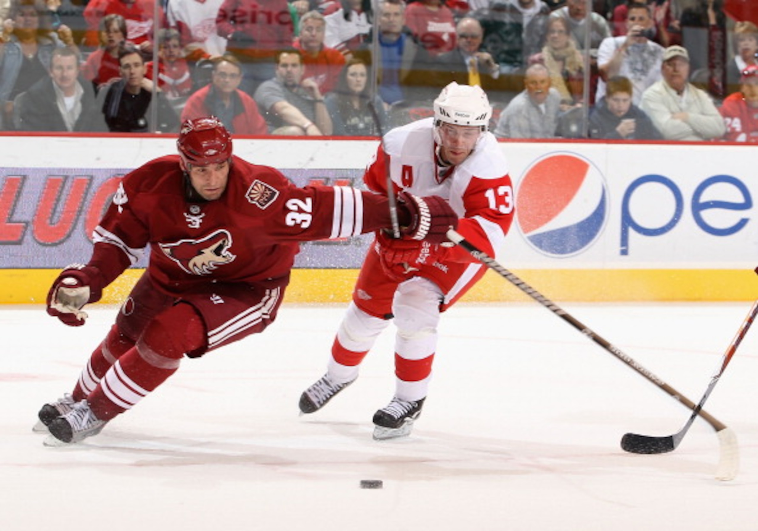 GLENDALE, AZ - MARCH 05:  Pavel Datsyuk #13 of the Detroit Red Wings battles for a loose puck with Michal Rozsival #32 of the Phoenix Coyotes during the NHL game at Jobing.com Arena on March 5, 2011 in Glendale, Arizona. The Coyotes defeated the Red Wings