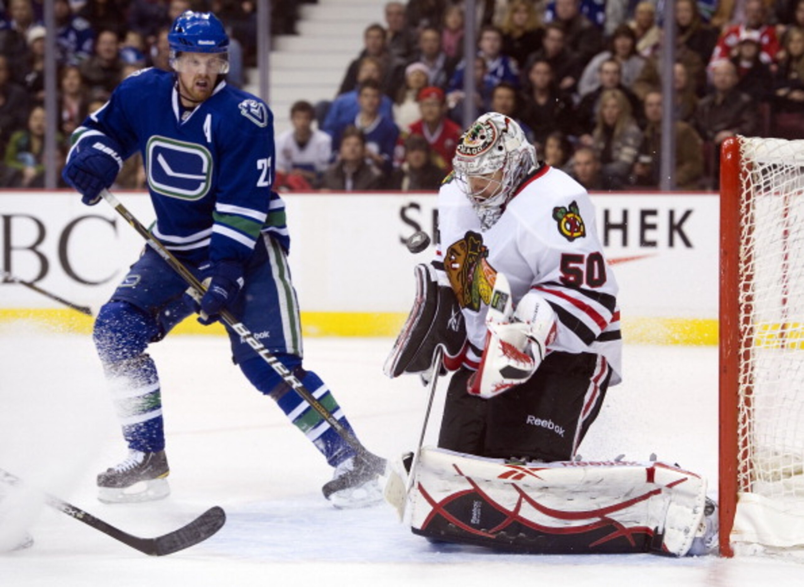 VANCOUVER, CANADA - NOVEMBER 20: Goalie Corey Crawford #50 of the Chicago Blackhawks makes a save while Daniel Sedin #22 looks for a rebound during the second period in NHL action on November 20, 2010 at Rogers Arena in Vancouver, British Columbia, Canada