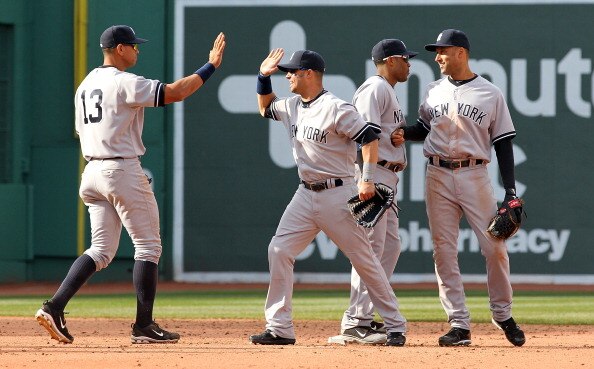 BOSTON, MA - APRIL 9:  Derek Jeter #2 of the New York Yankees celebrates with teammates Robinson Cano #24, Alex Rodriguez #13 and Nick Swisher #33 after defeating the Red Sox 9-4 at Fenway Park April 9, 2011 in Boston, Massachusetts. (Photo by Jim Rogash/