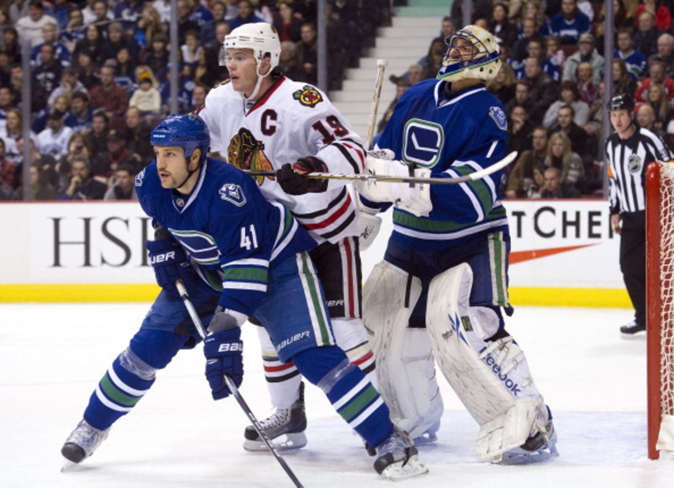 VANCOUVER, CANADA - NOVEMBER 20: Goalie Roberto Luongo #1 of the Vancouver Canucks tries to keep an eye on the play as Jonathan Toews #19 of the Chicago Blackhawks and Andrew Alberts #41 of the Canucks battle for position in front of the net during the fi