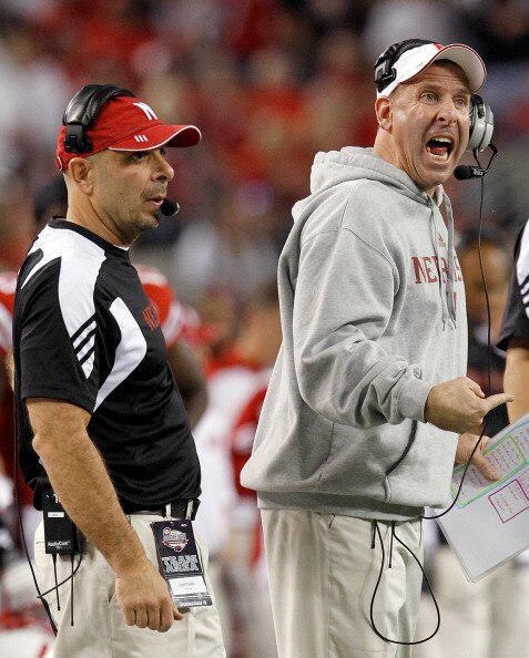 ARLINGTON, TX - DECEMBER 04:  Head coach Bo Pelini (R) of the Nebraska Cornhuskers and defensive coordinator Carl Pelini lead their team against the Oklahoma Sooners at Cowboys Stadium on December 4, 2010 in Arlington, Texas. The Sooners beat the Cornhusk