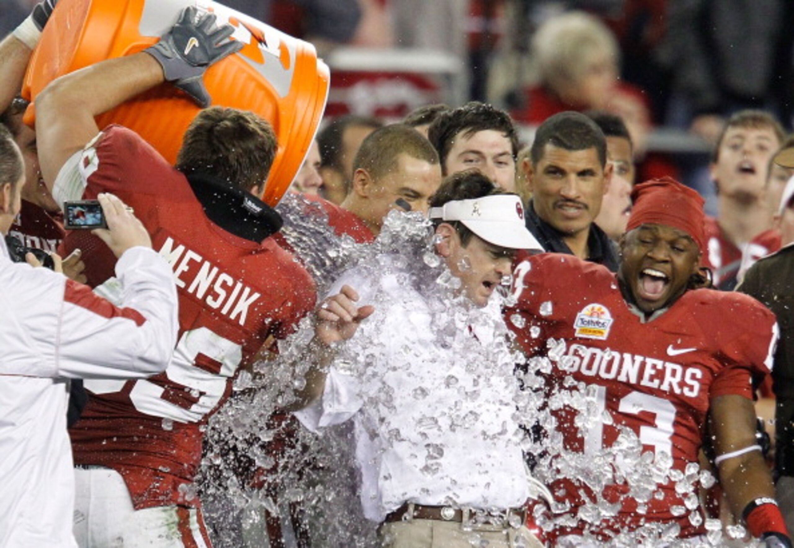 GLENDALE, AZ - JANUARY 01:  Head coach Bob Stoops has a Gatorade bucket dumped on him by Eric Mensik #69 late in the fourth quarter before the Sooners 48-20 victory against the Connecticut Huskies during the Tostitos Fiesta Bowl at the Universtity of Phoe
